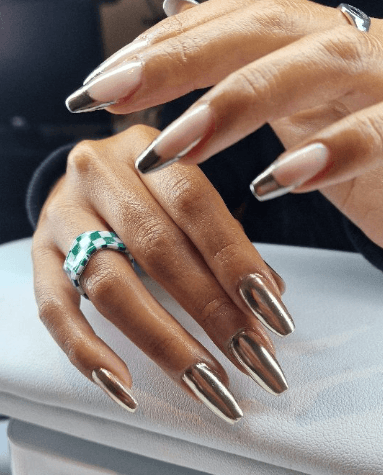 Hand with autumn-colored nails holding a brown purse