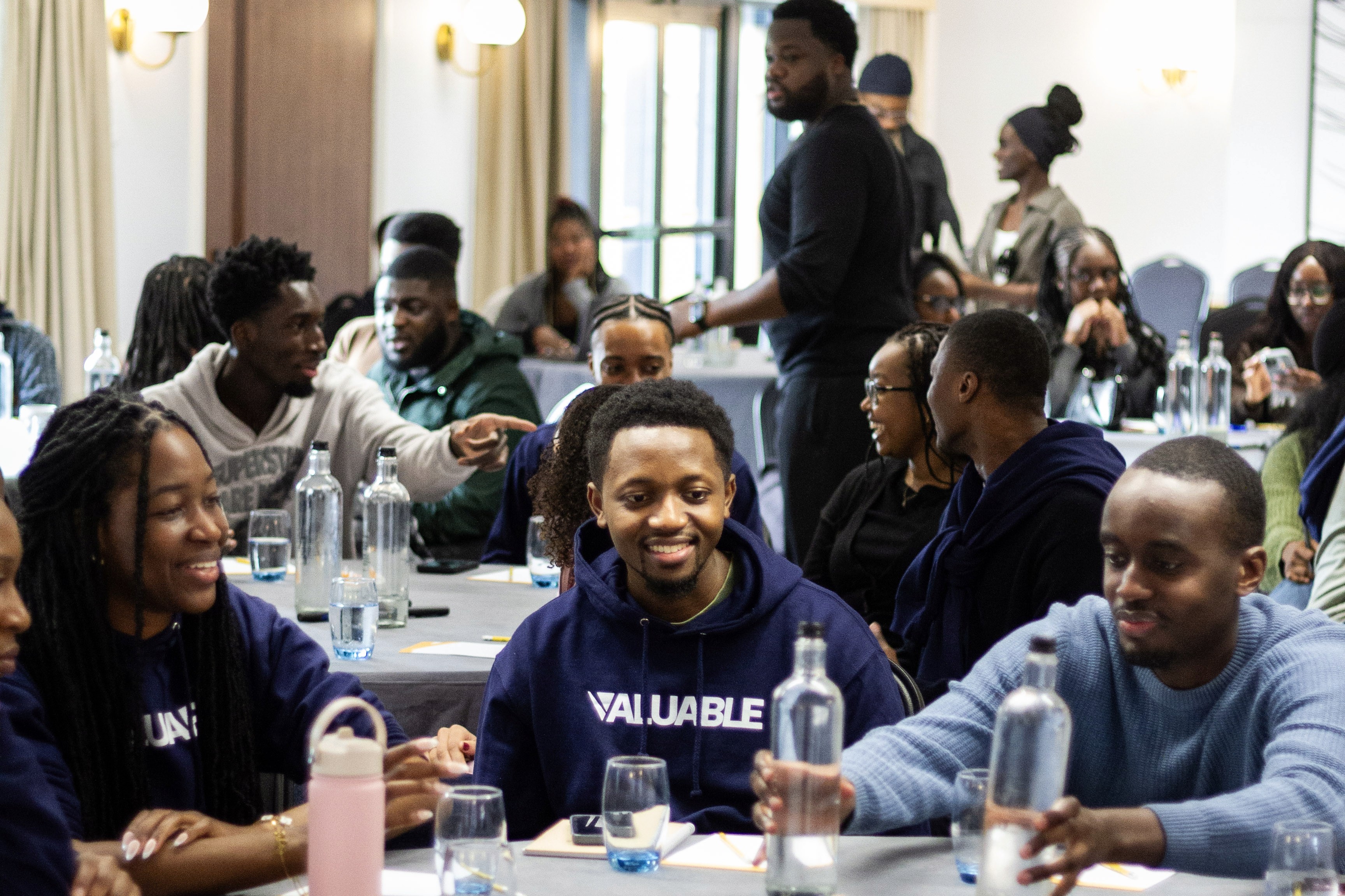 Diverse group of young adults in a workshop, smiling and engaged.