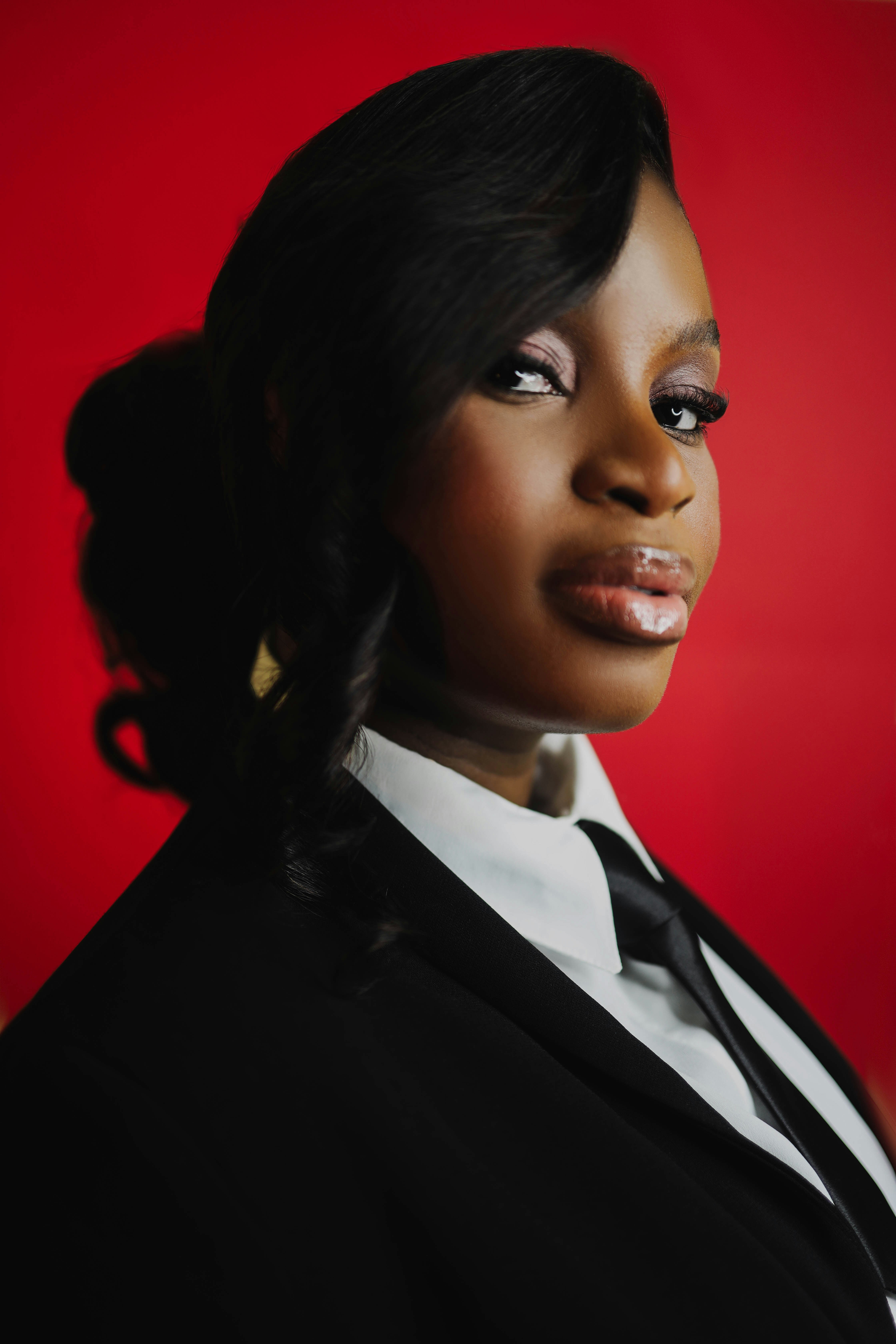 A woman in a suit with a red background.