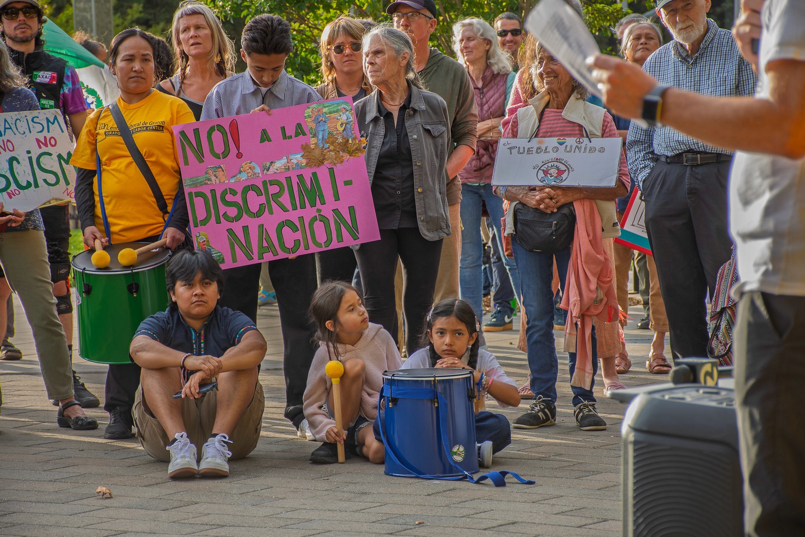 Three children jumping in burlap sacks during a race.