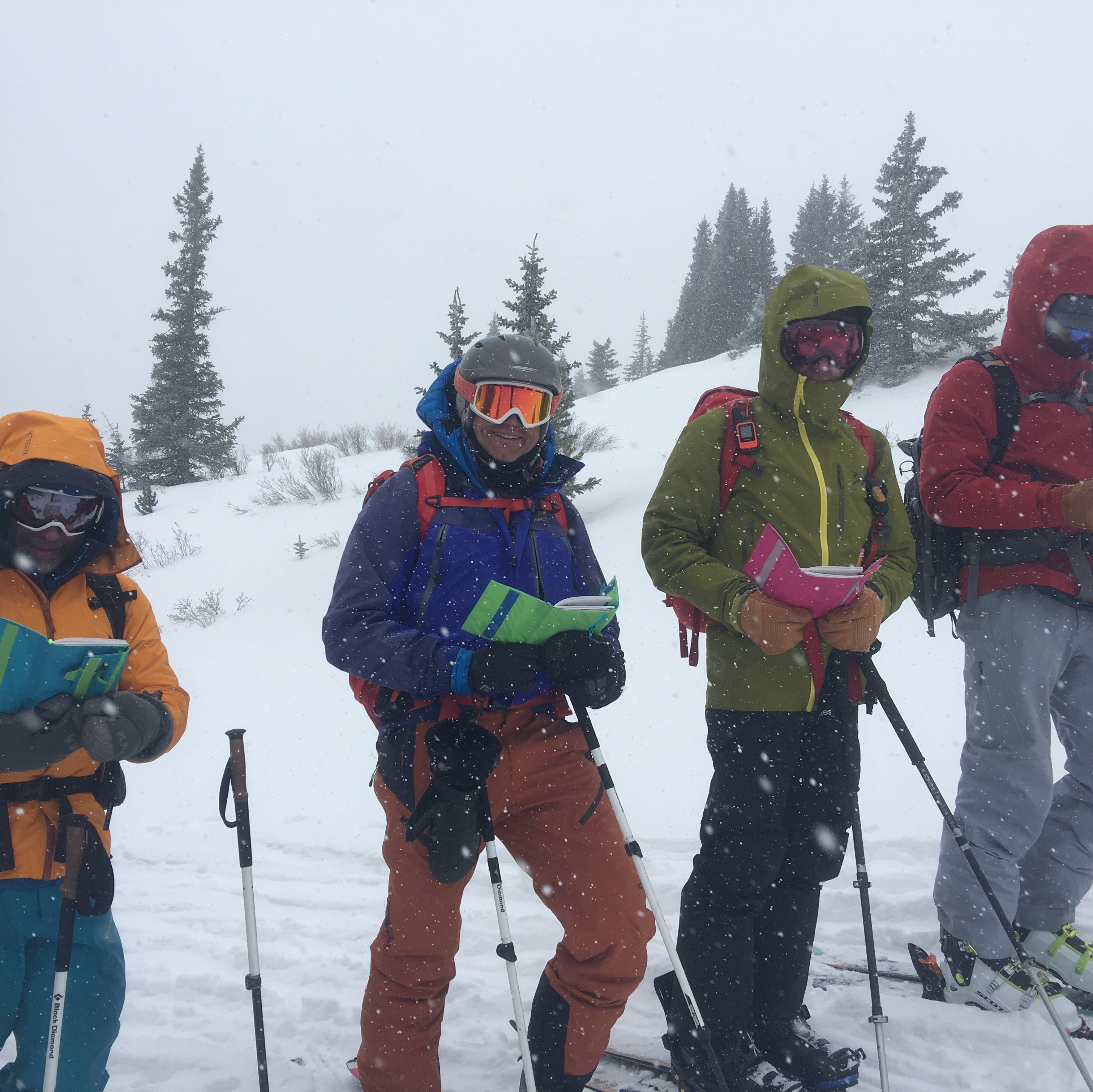 Avalanche course students look in their field guides for information