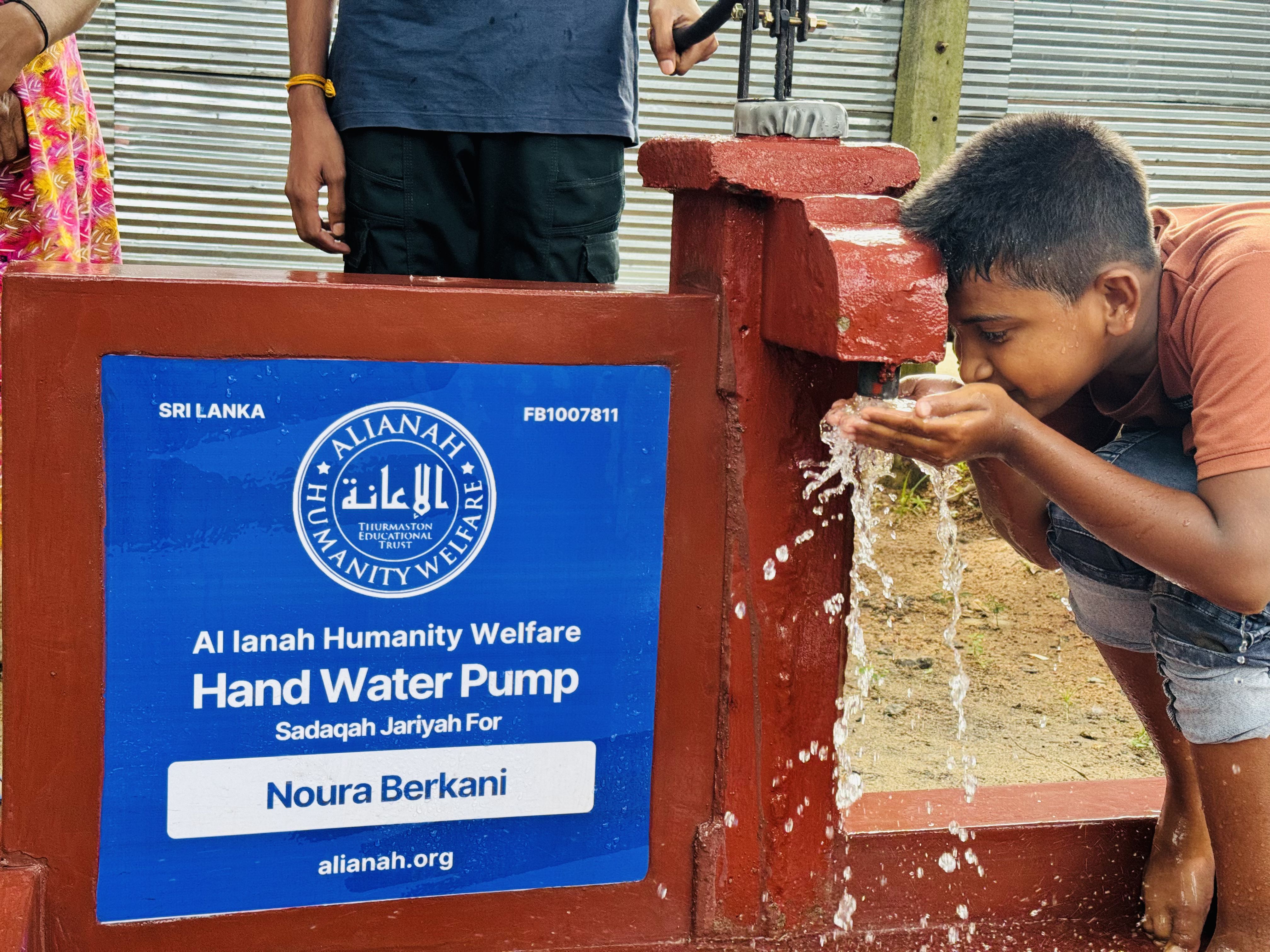 man drinking water from water pump