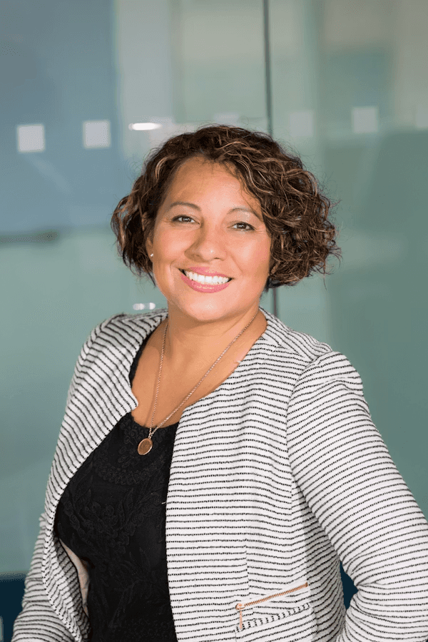 Smiling professional woman standing in an office setting.