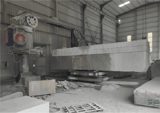 Interior view of a workshop with the Intelligent Block Squaring Wire Saw Machine processing a massive stone block, showcasing its industrial-grade capabilities.