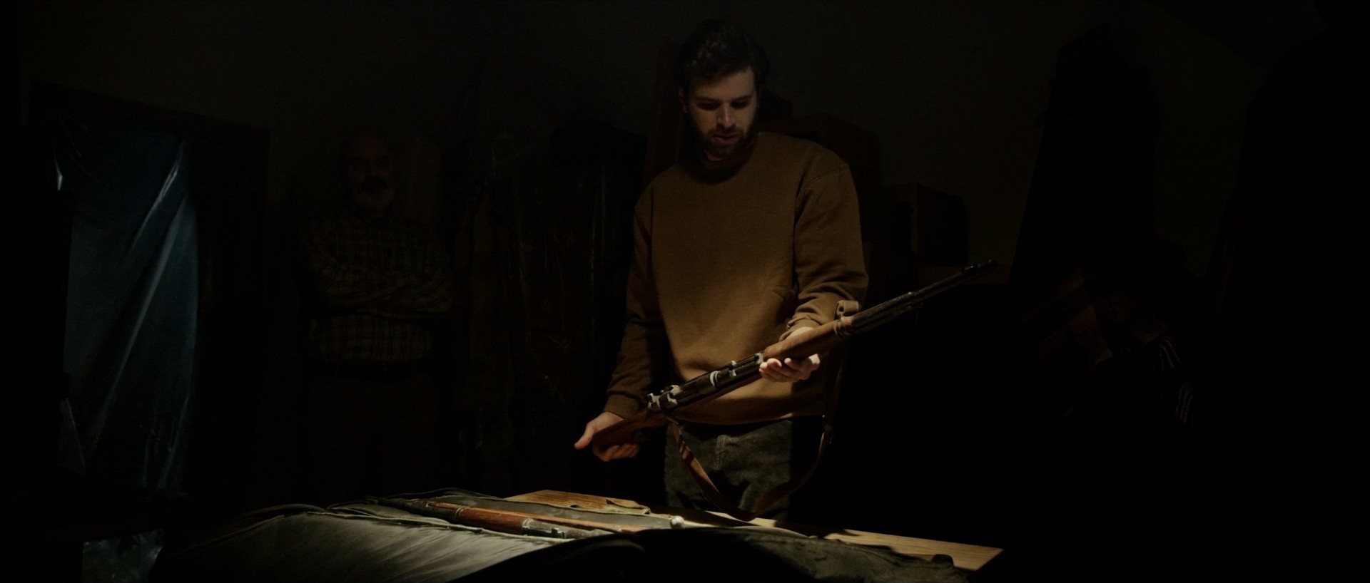 Close-up of hands cleaning a hunting rifle, detailed shot from short film "Tradition".