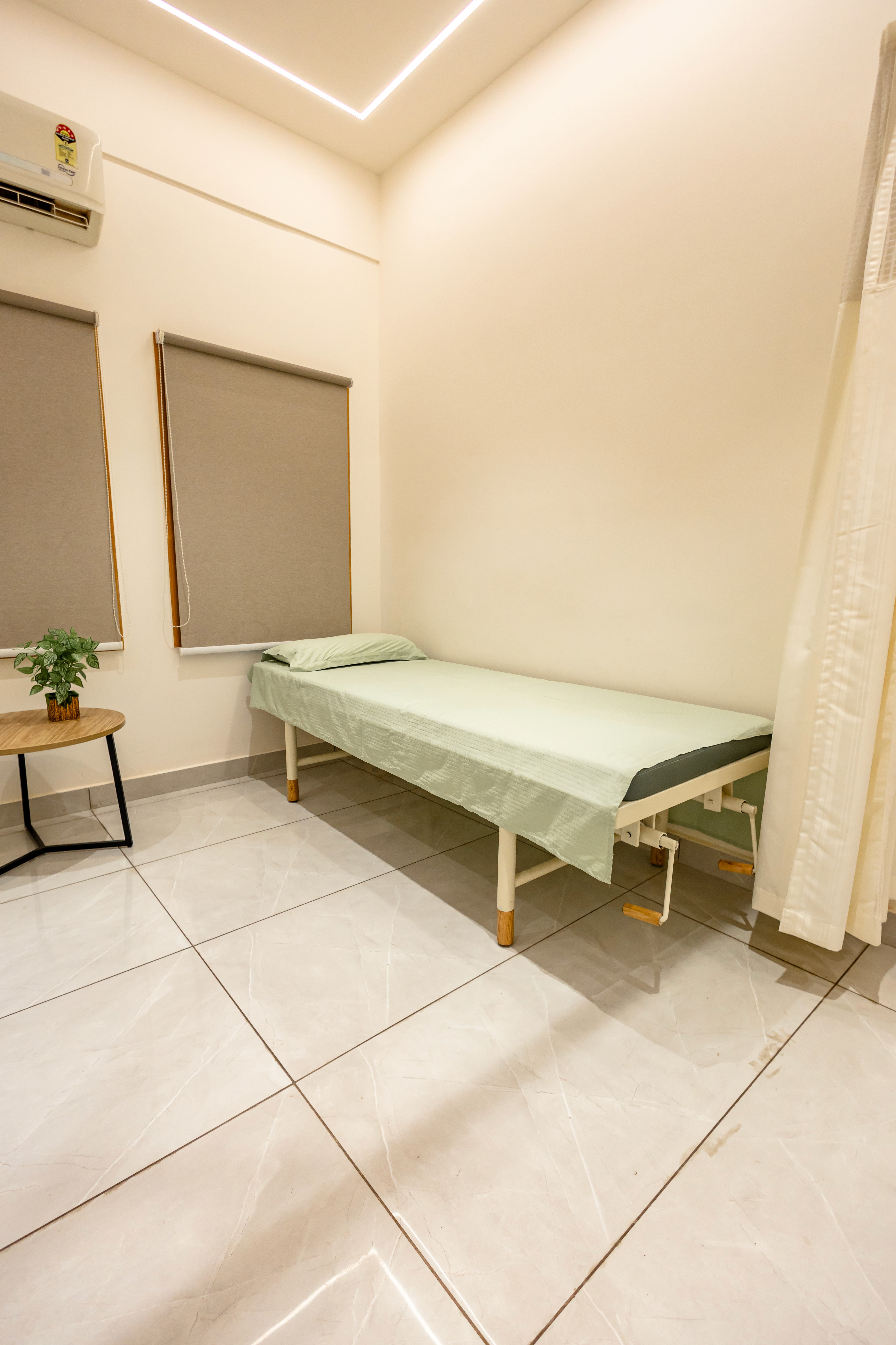 Patient room at Seren Med Lounge with medical equipment, oxygen cylinder, and air conditioning for emergency and post-procedure care.