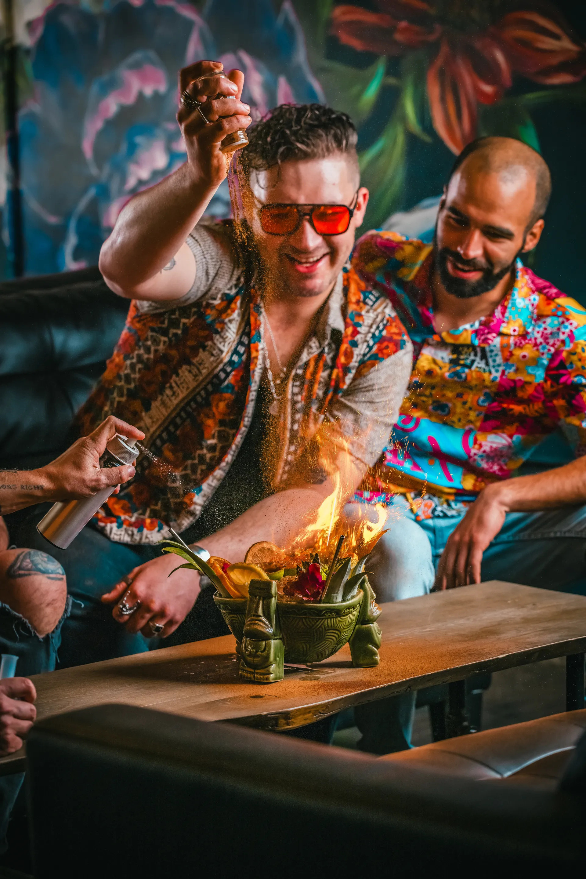 Bartender pouring cinnamon over a flaming punch bowl