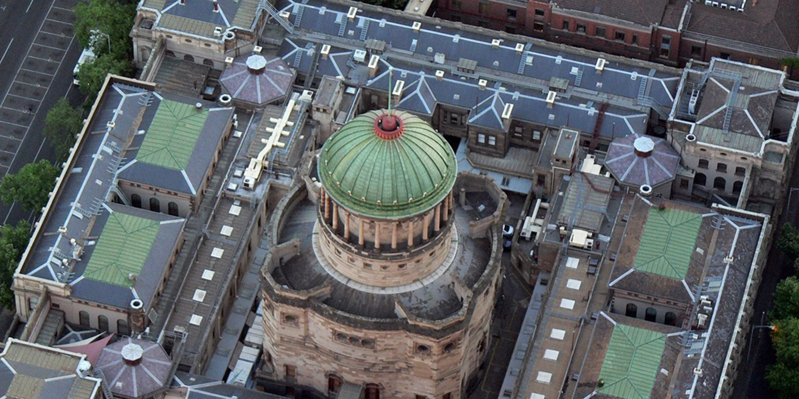 Aerial view of a domed sandstone building with a green copper dome, for the Judicial College of Victoria's Wisdom Shared