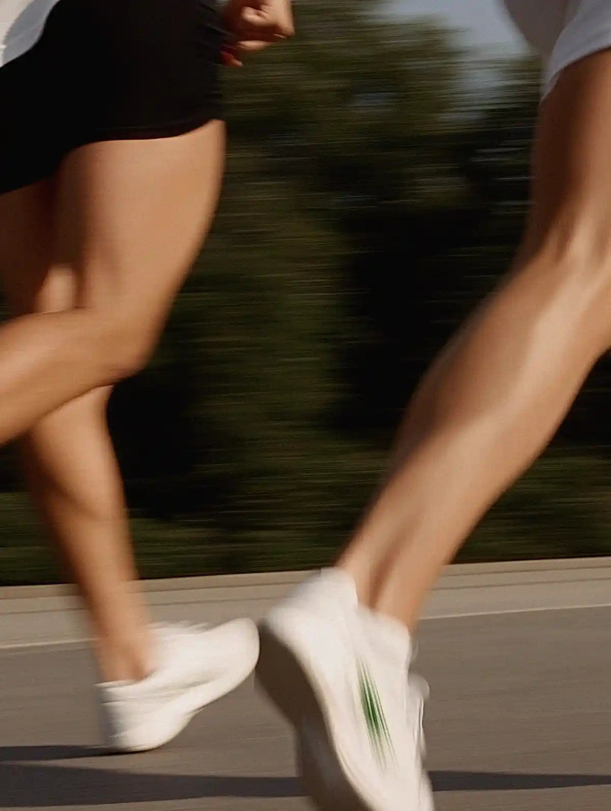 A professional woman multitasking with a laptop and phone, dressed in a gray pinstripe suit, surrounded by magazines in a modern setting.
