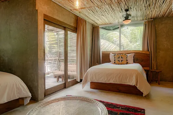 Oceanfront Room at Nômade Tulum highlighting spacious bed and harmonious architecture.