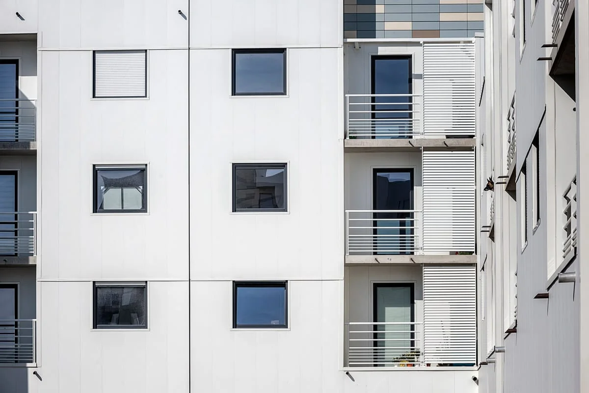 Immeuble résidentiel moderne, façade blanche à fenêtres carrées et balcons — photographie d’architecture à Dunkerque