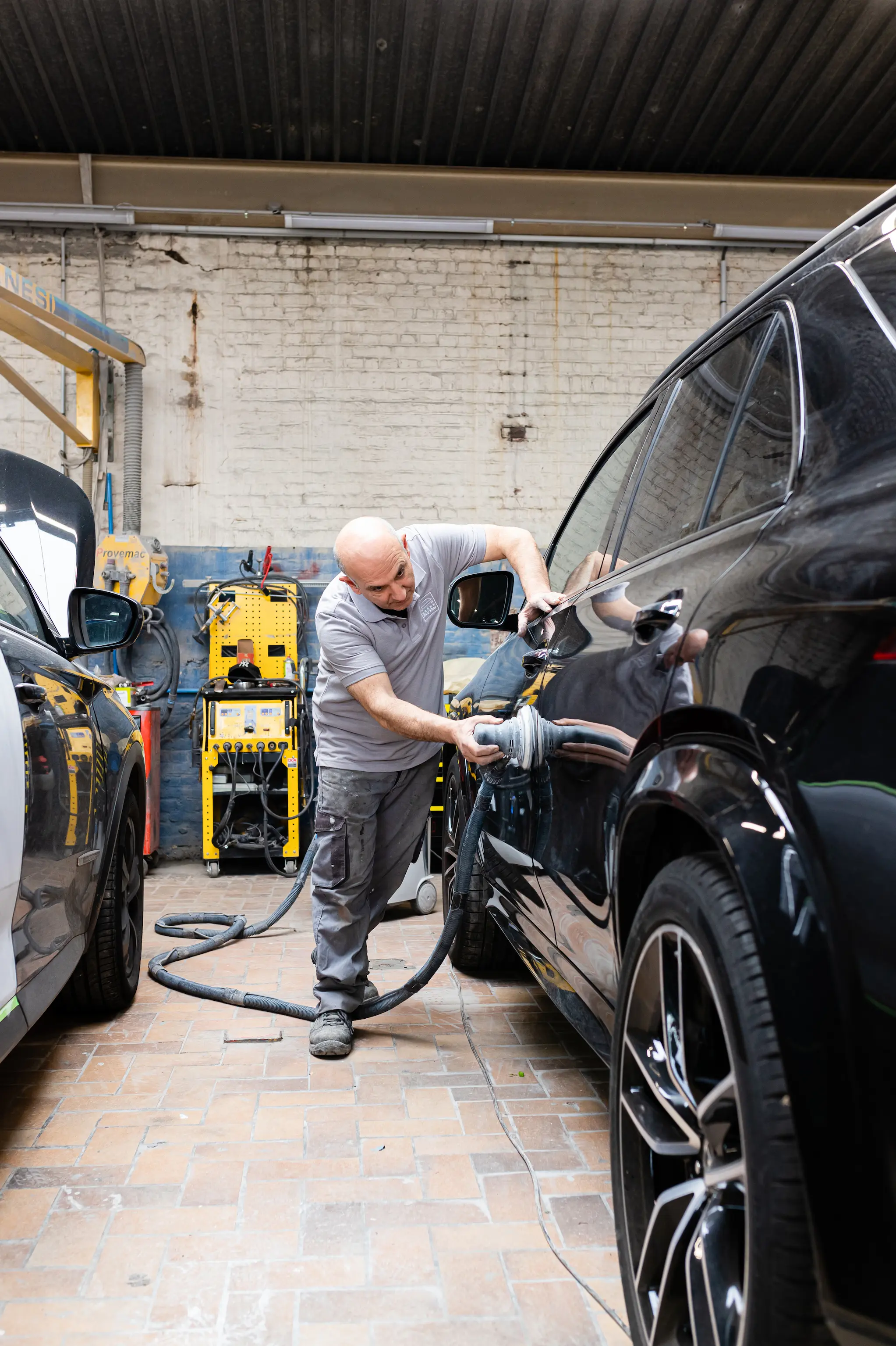 Ouvrier qui retire la rouille et l’oxydation de la carrosserie de ma voiture