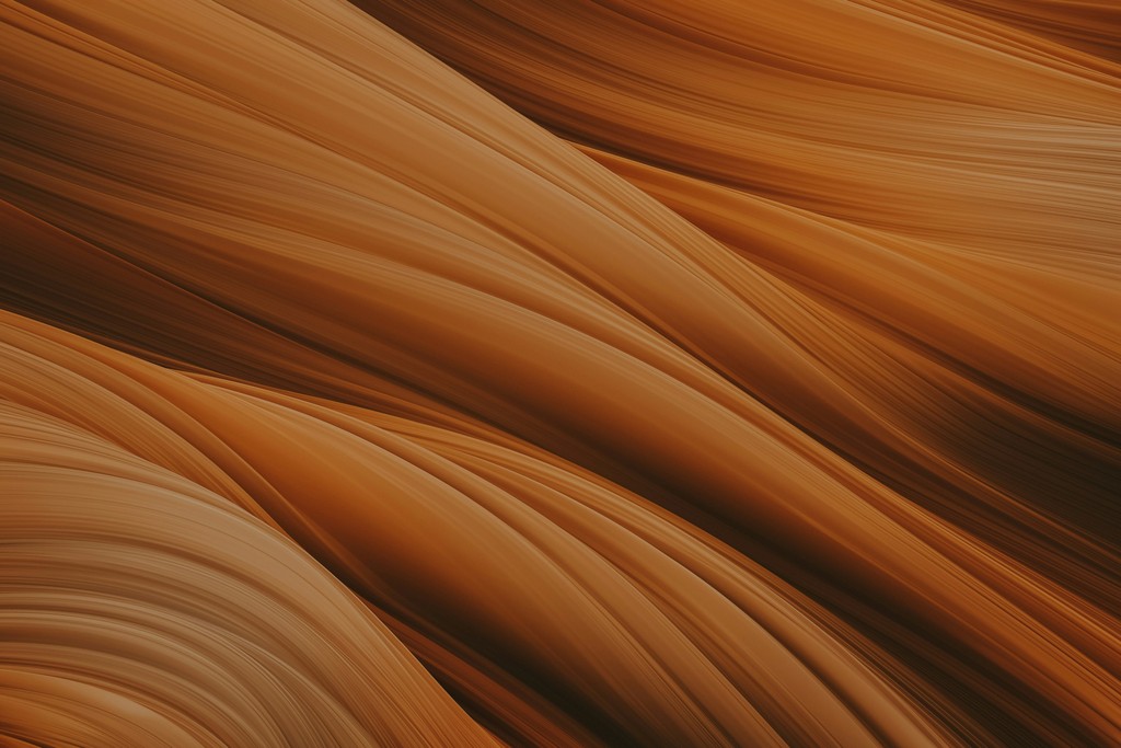 Abstract image of smooth, flowing orange and brown lines resembling waves or textures in natural materials.