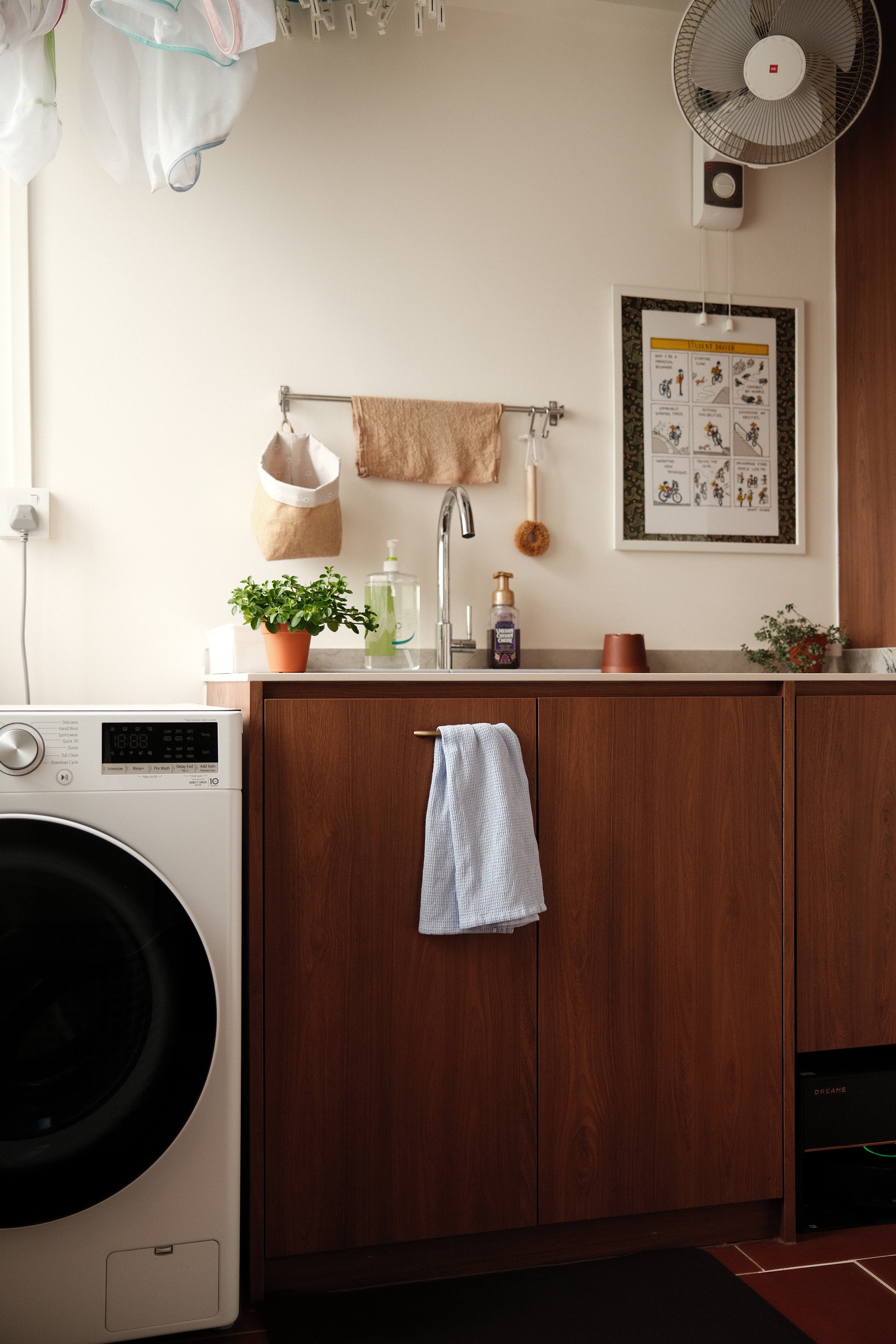 A thoughtfully designed utility zone where warm wood cabinetry, greenery, and clean lines elevate daily routines.