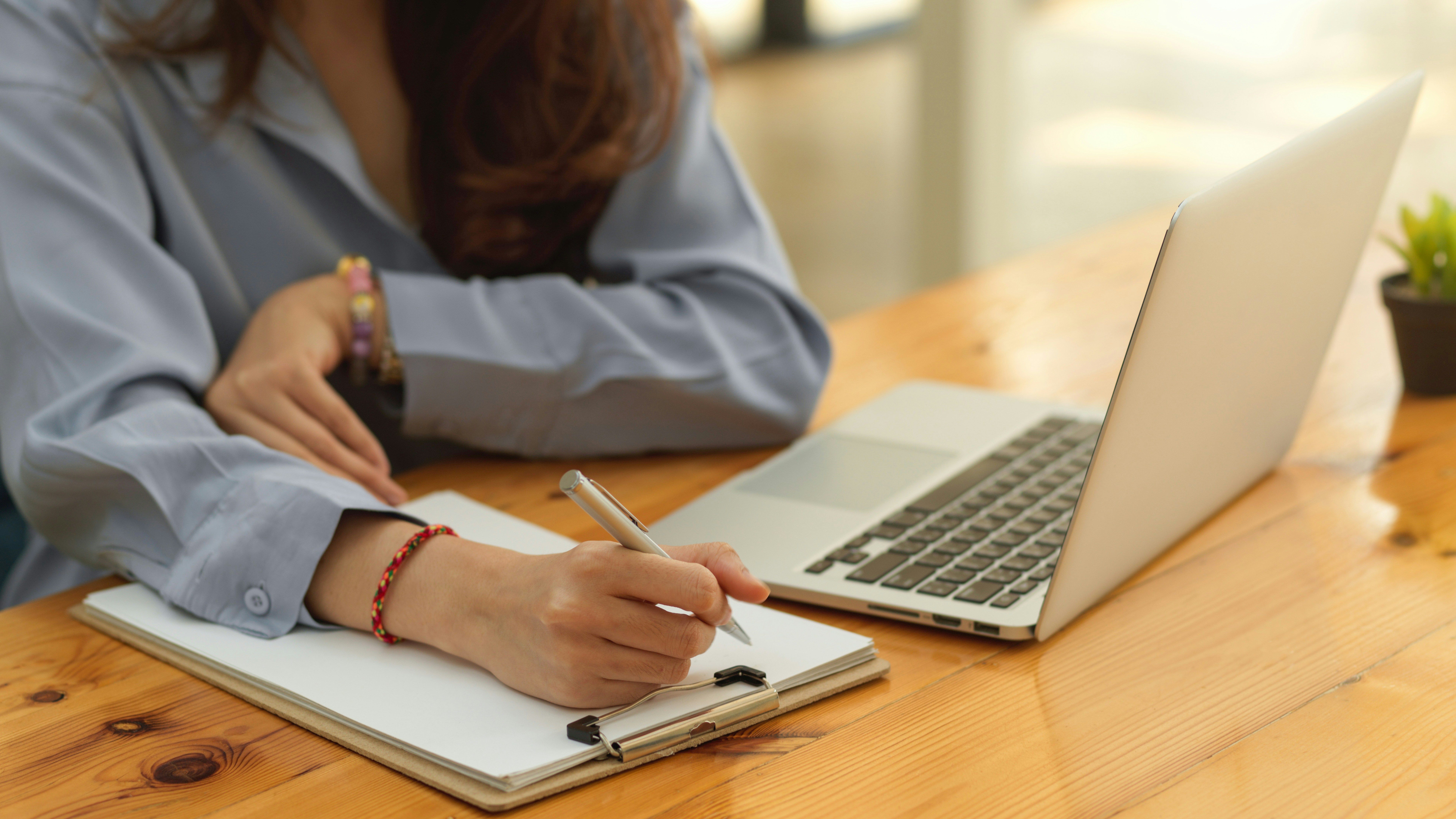 Hands typing on a laptop with a coffee cup nearby
