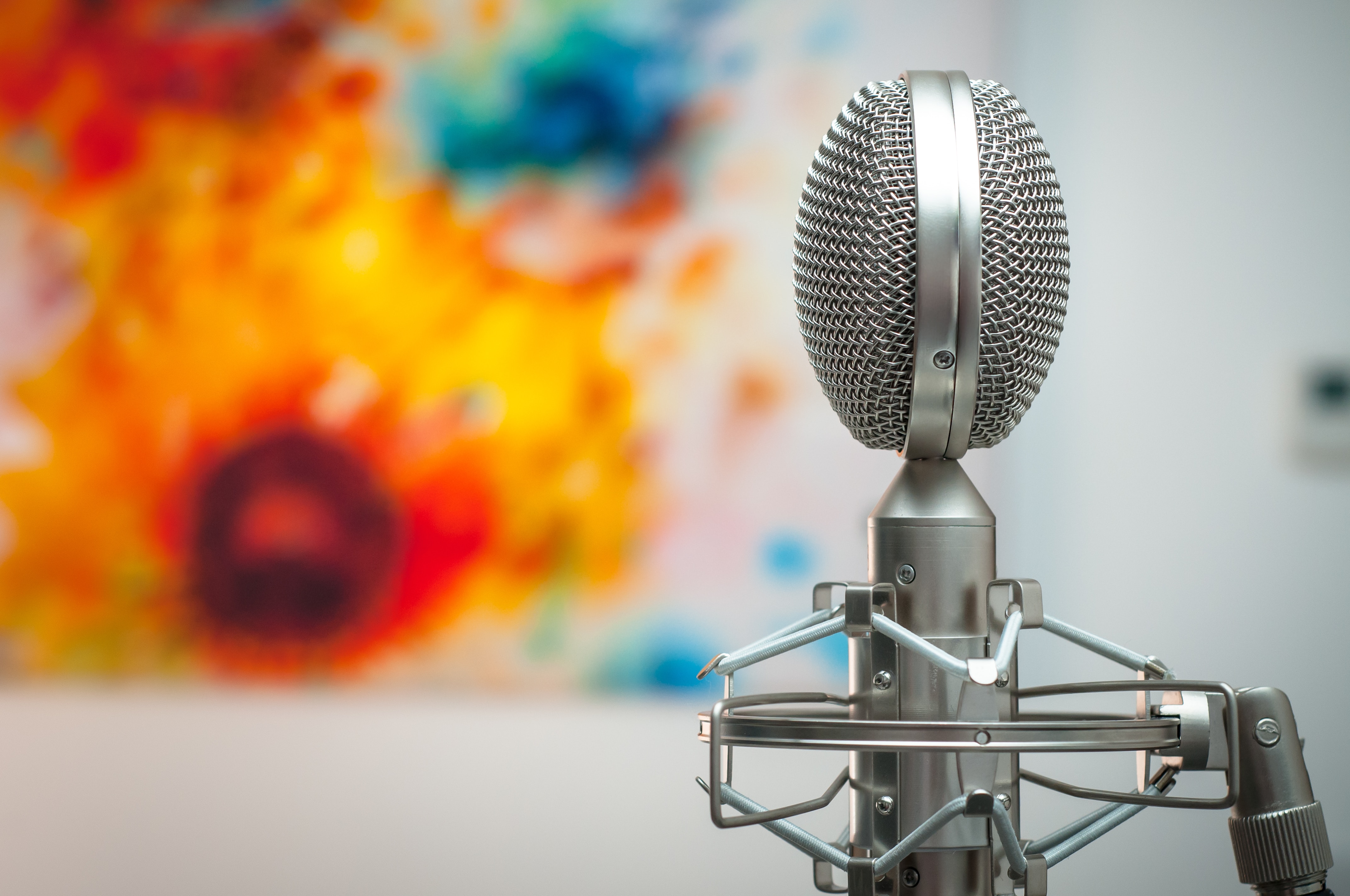 a studio mic in a coloured background - mubert vs musicfy