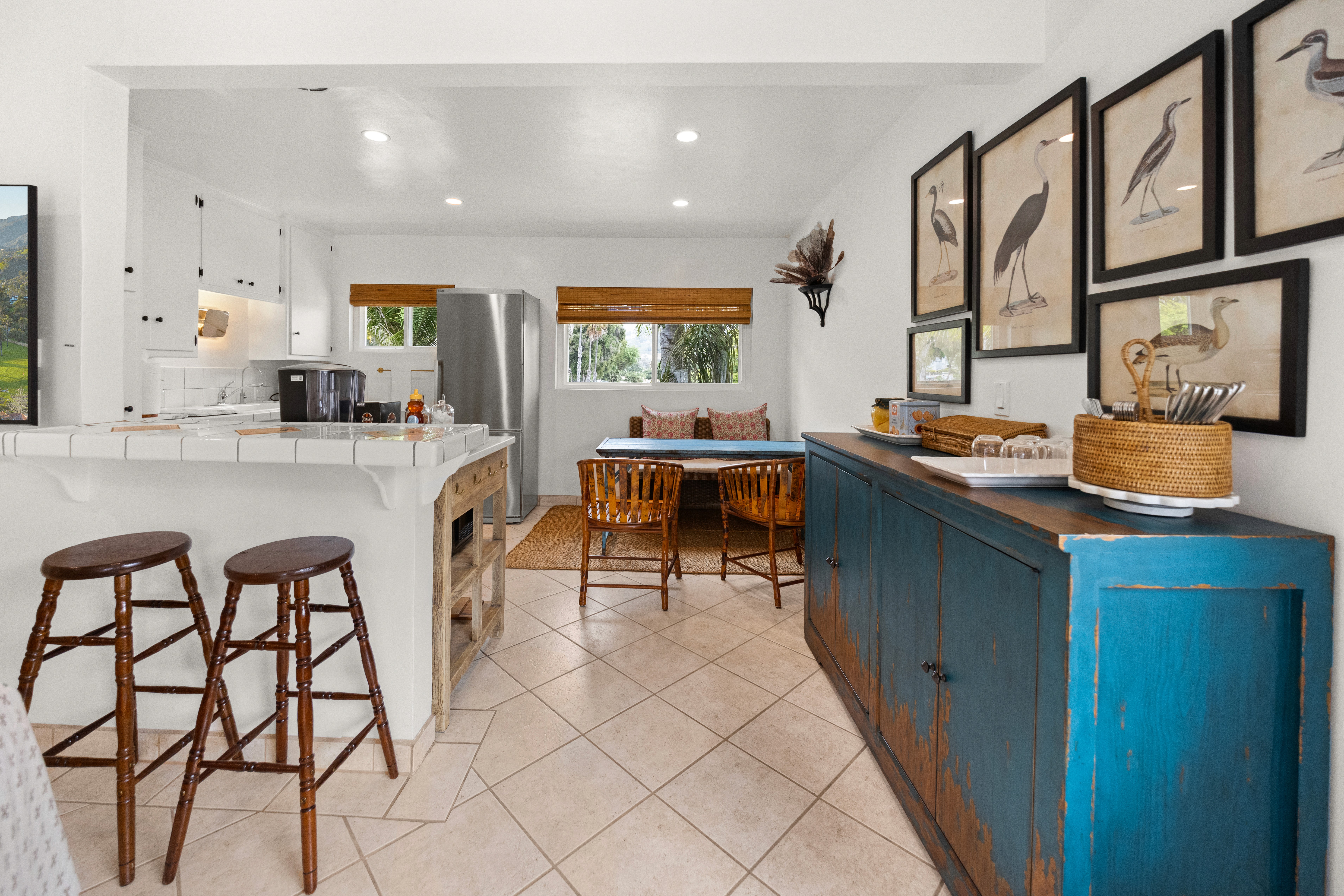 Inviting kitchen and dining space featuring a rustic sideboard, bar seating, and plenty of natural light.
