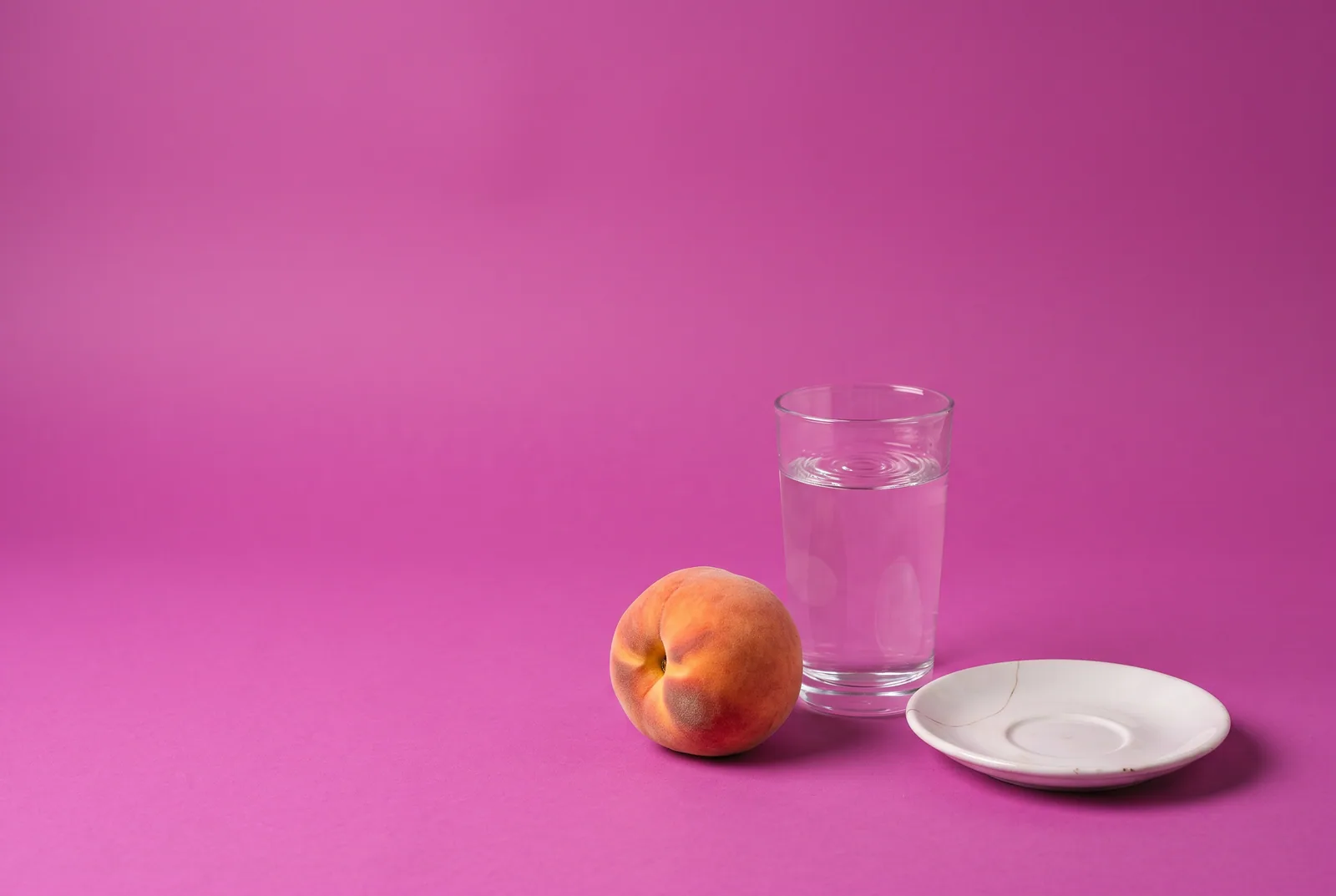 A bruised peach beside a rippling glass of water and a cracked saucer, how your wife may react when you tell her about porn addiction