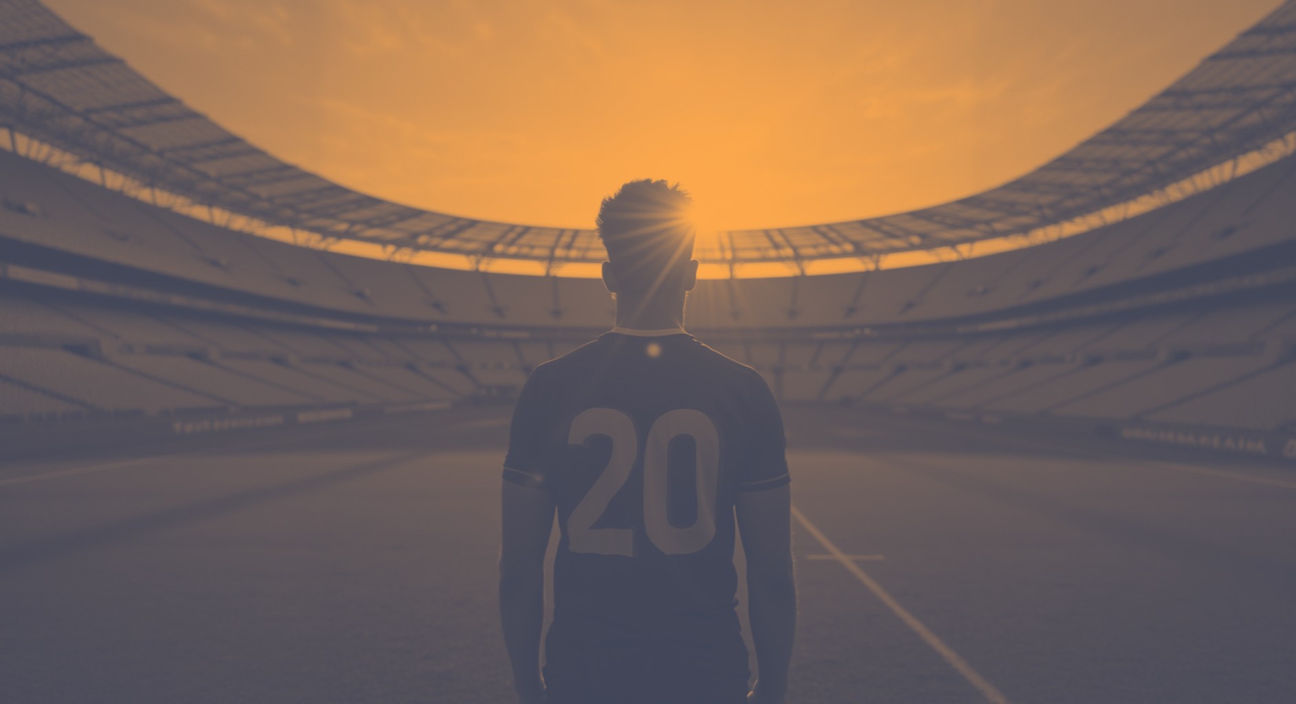 A player in the center of a football stadium staring onto the field