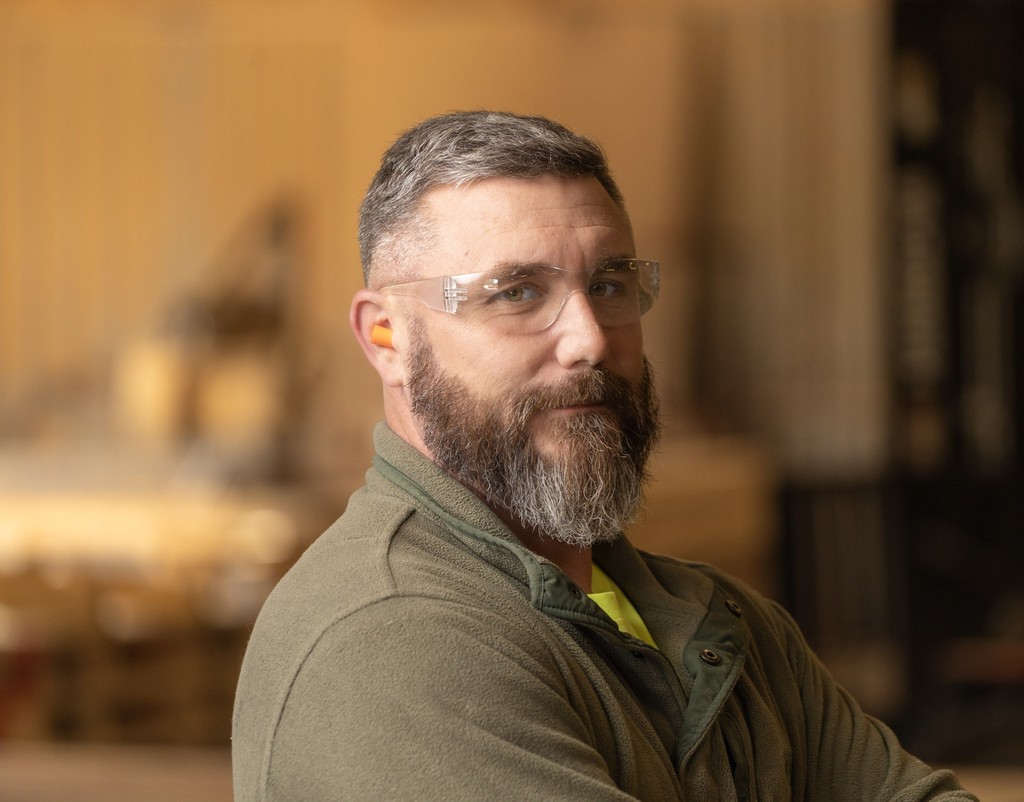 A man standing in a room with lights hanging from the ceiling