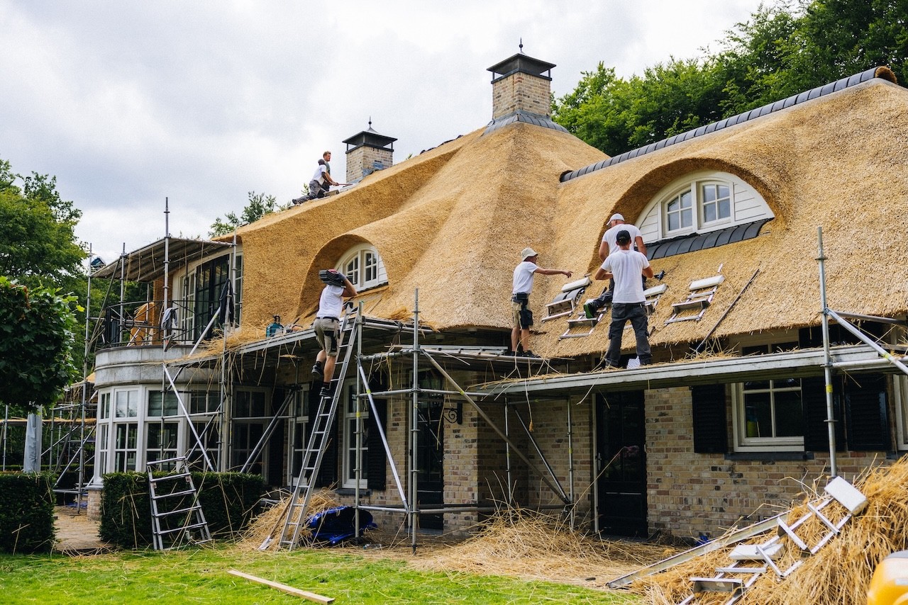Rietdekkers van Rietdekkersbedrijf van Dijk Putten die bezig zijn met een renovatie