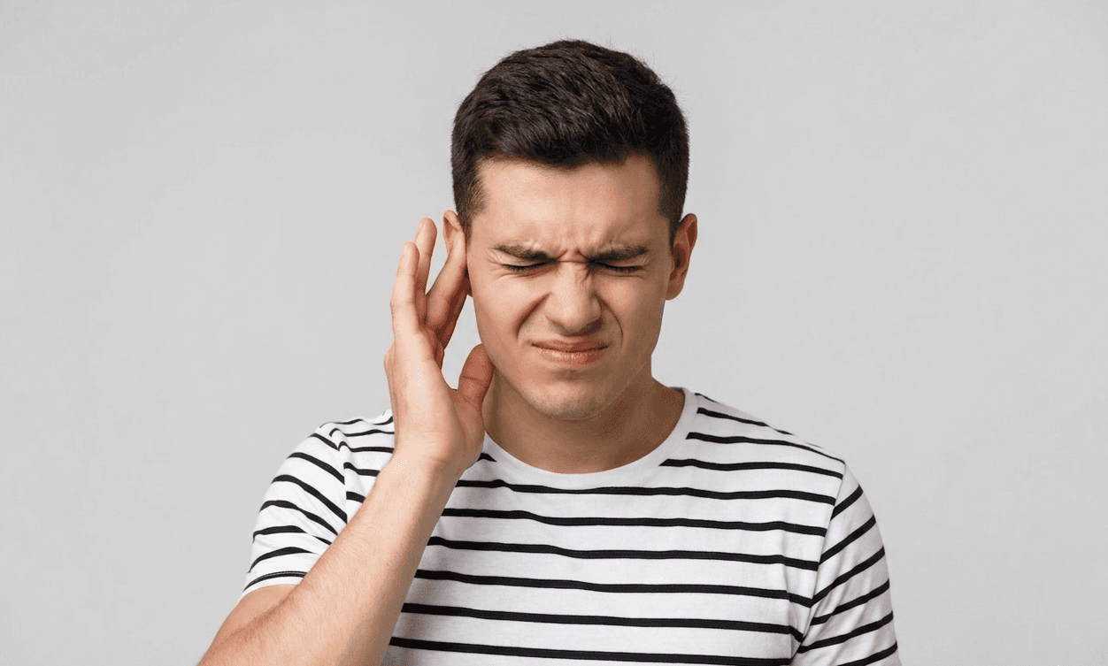 Man experiencing jaw discomfort and ear pain associated with TMJ-related bite strain