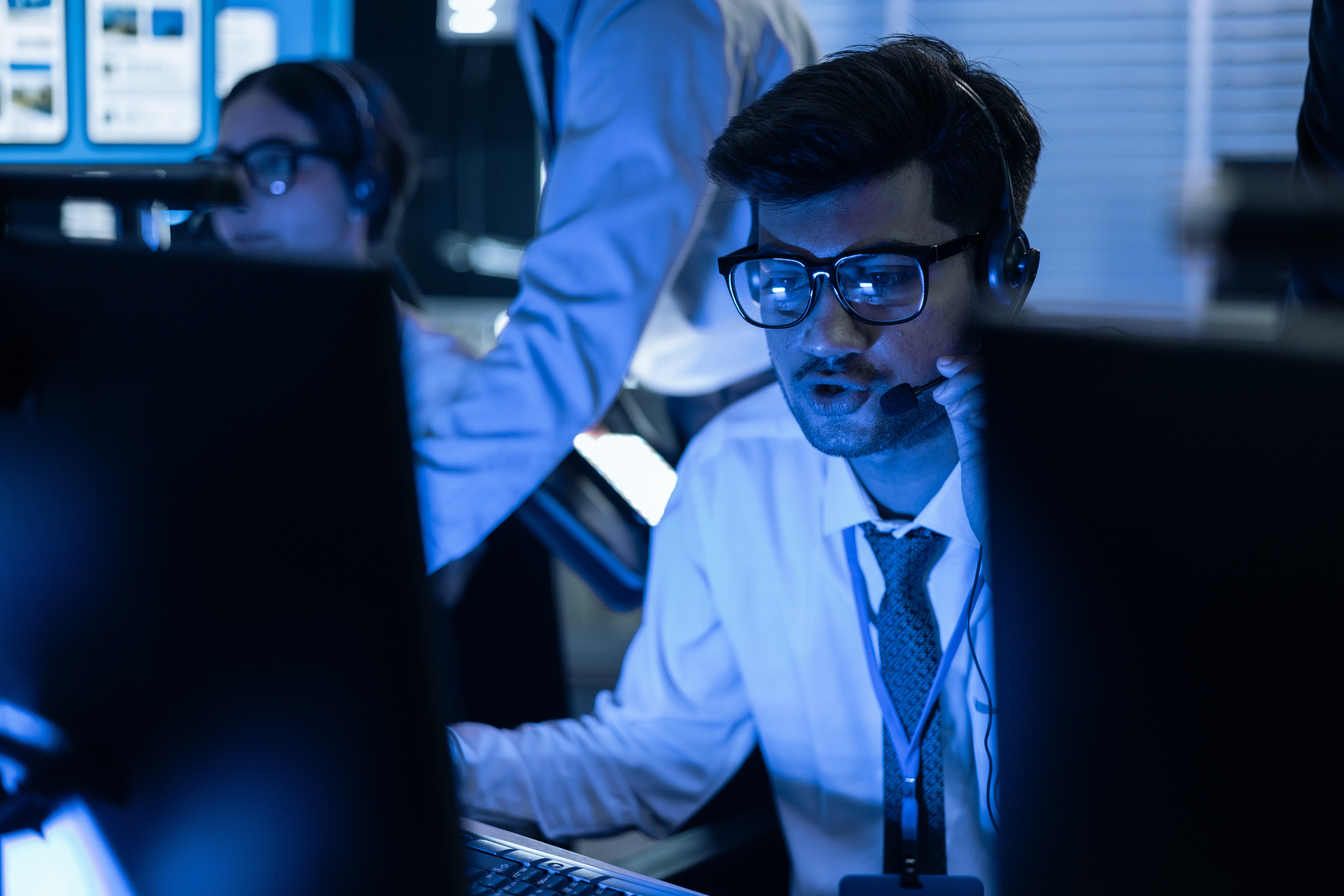 Analyst monitoring cloud cost alerts on multiple screens