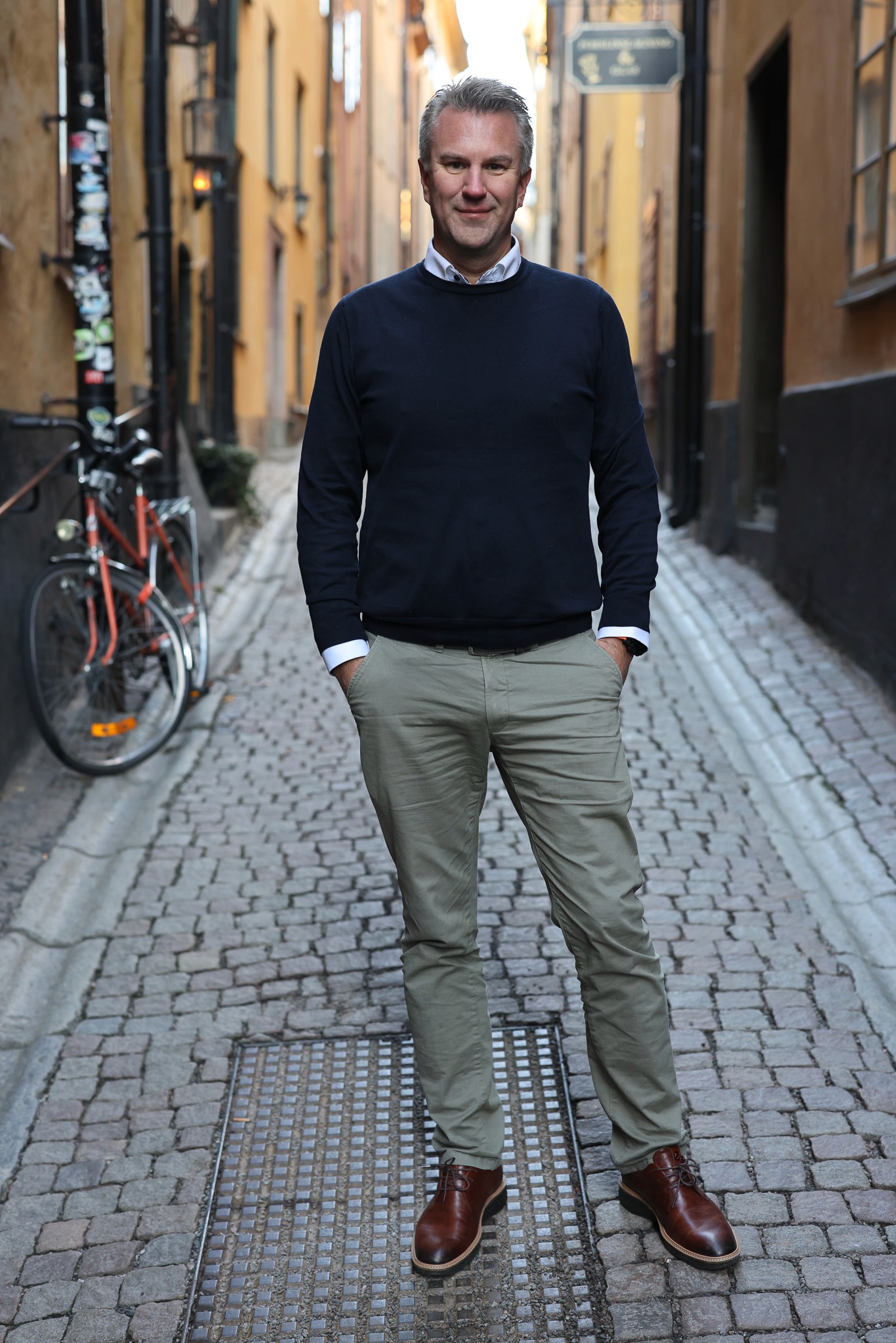 People seated around a table with laptops, 2 individuals engaged in work tasks.