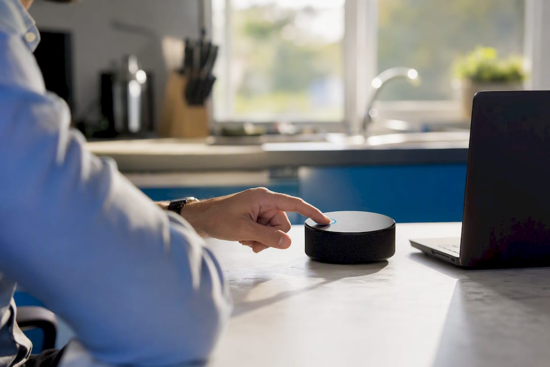 Hands activating AI voice assistant device