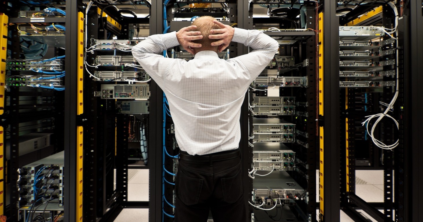 Ein Serverraum in Unordnung, rote Warnleuchten blinken und symbolisieren einen IT-Notfall oder Datenverlust.