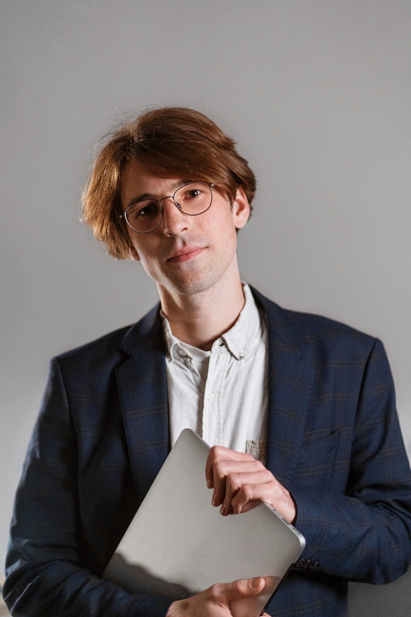 Modern bathroom featuring wooden cabinetry, a bathtub, a sleek sink, and natural light from a window.