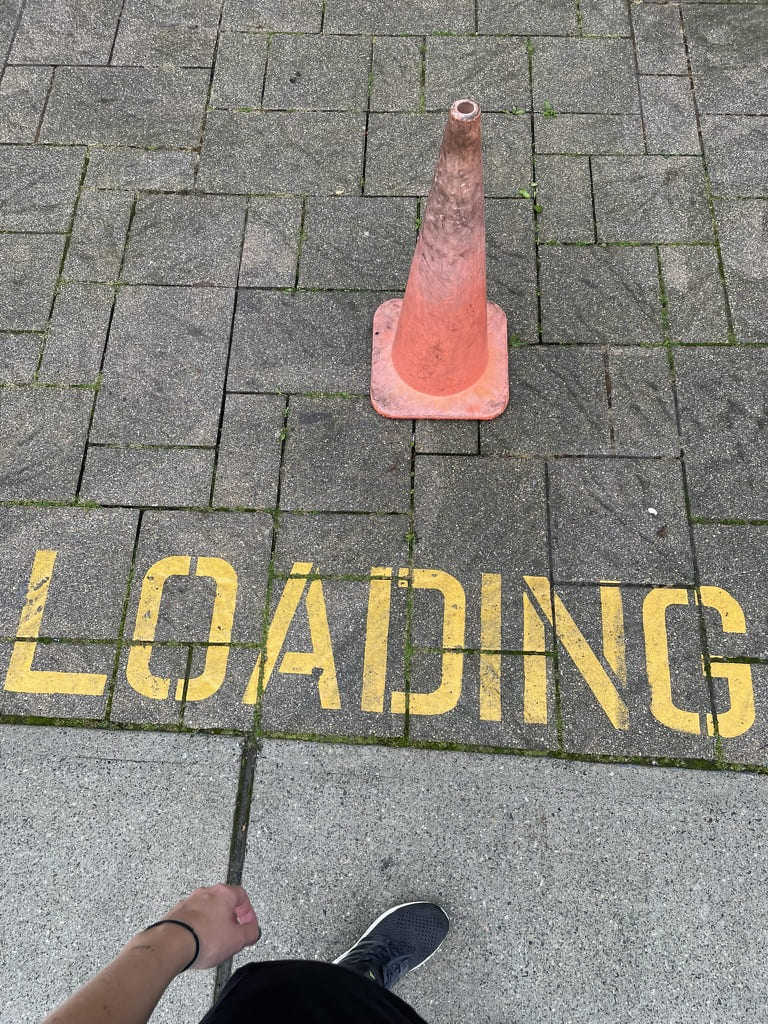 Faded purple cone with "loading" sign in yellow