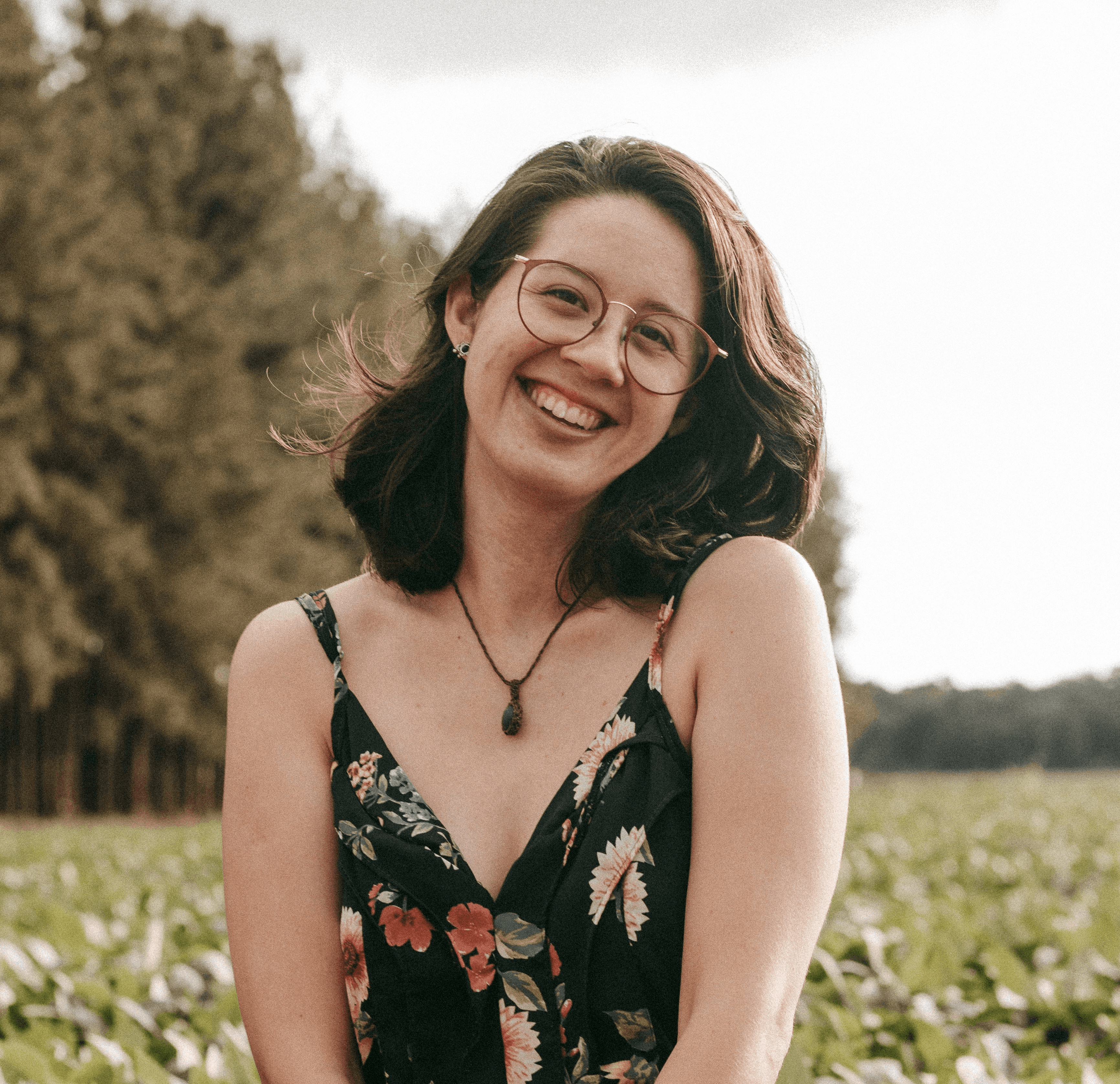 woman in black and red floral spaghetti strap dress smiling