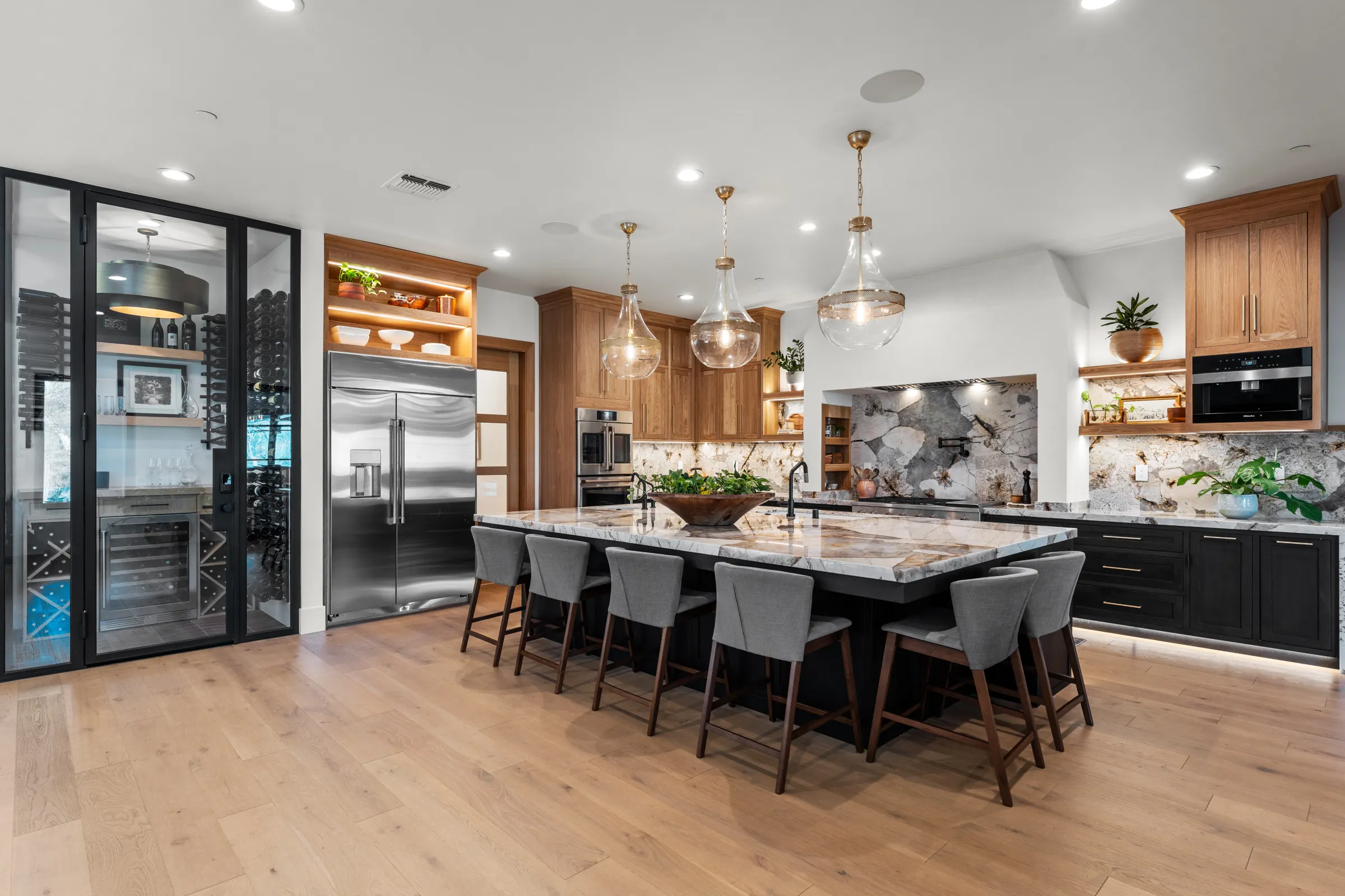 aKitchen with island, pendant lights and walk-in wine wall built by ERC