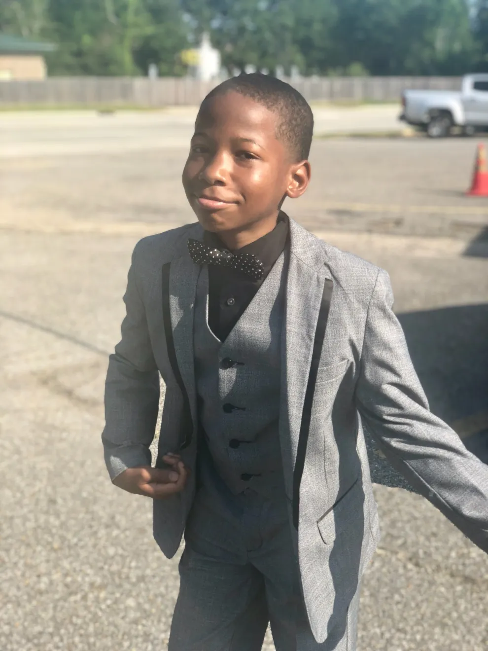 Young Karmelo in a gray suit