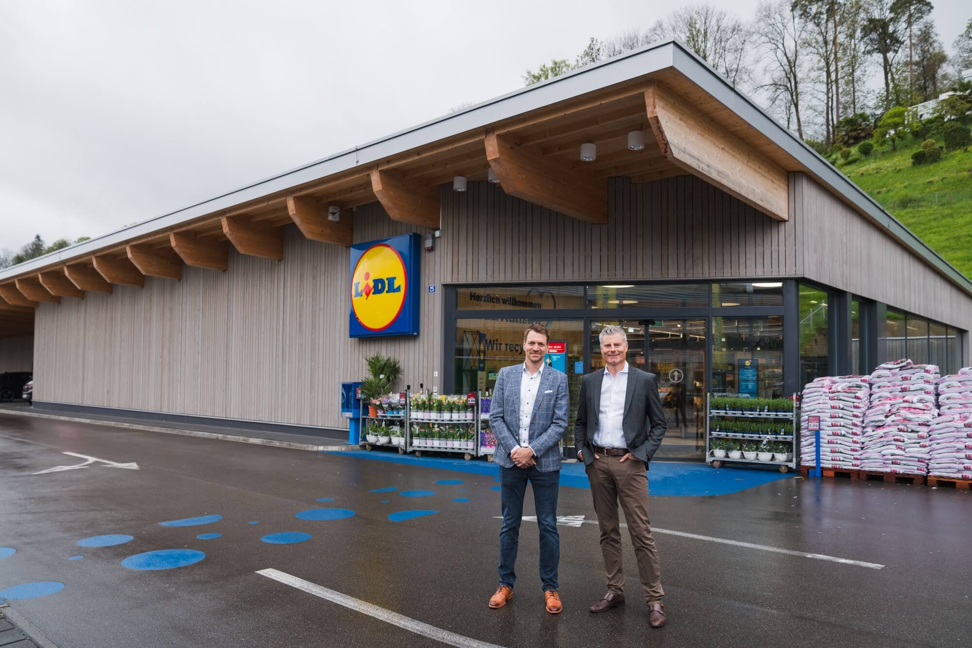 Zwei Vertreter vor der neuen Lidl-Filiale neben dem ALTO-Areal, vor modernem Holzbau mit grosszügigem Eingangsbereich und Quartierbezug.