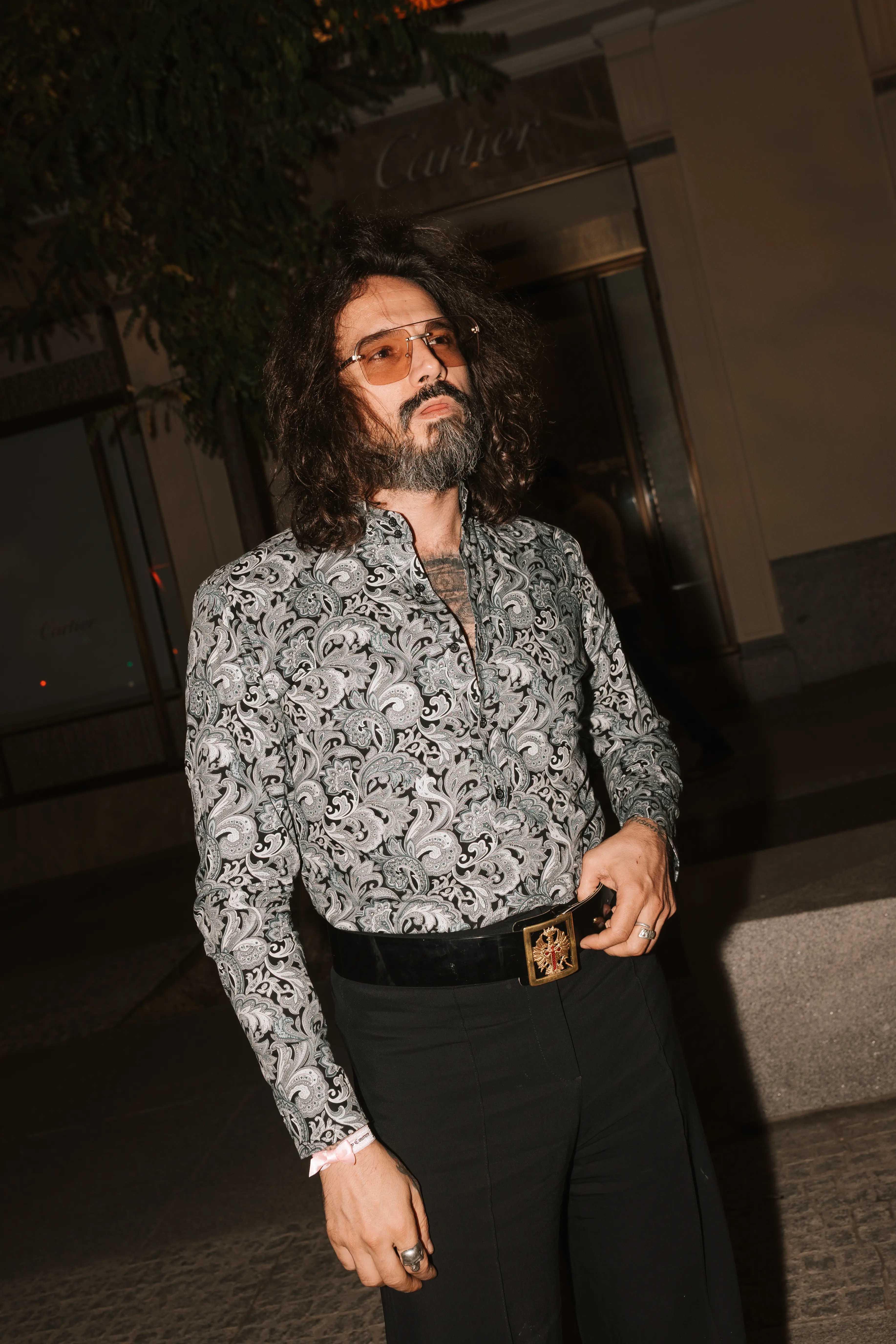 hombre con camisa negra estampada posando