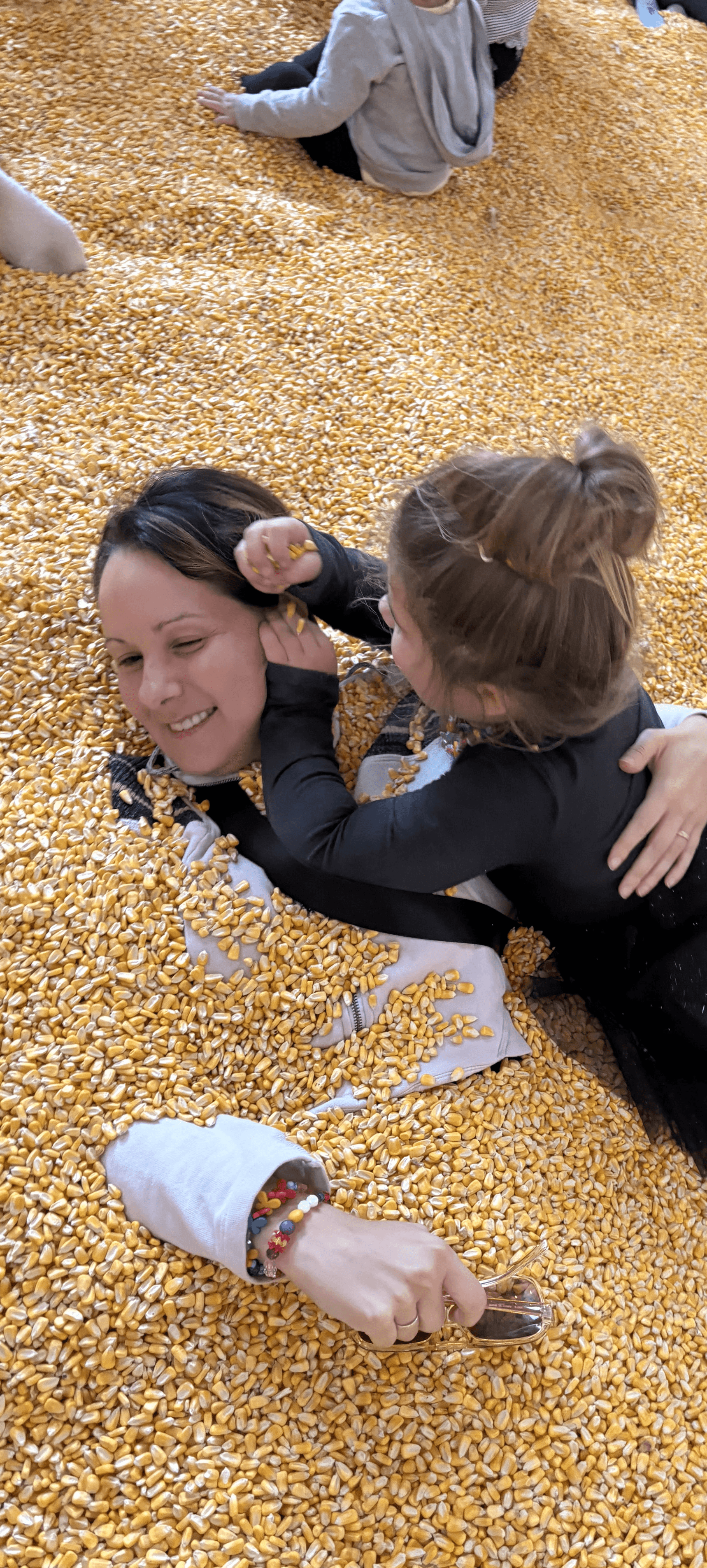 Portrait of a laughing person with curly hair wearing a white shirt