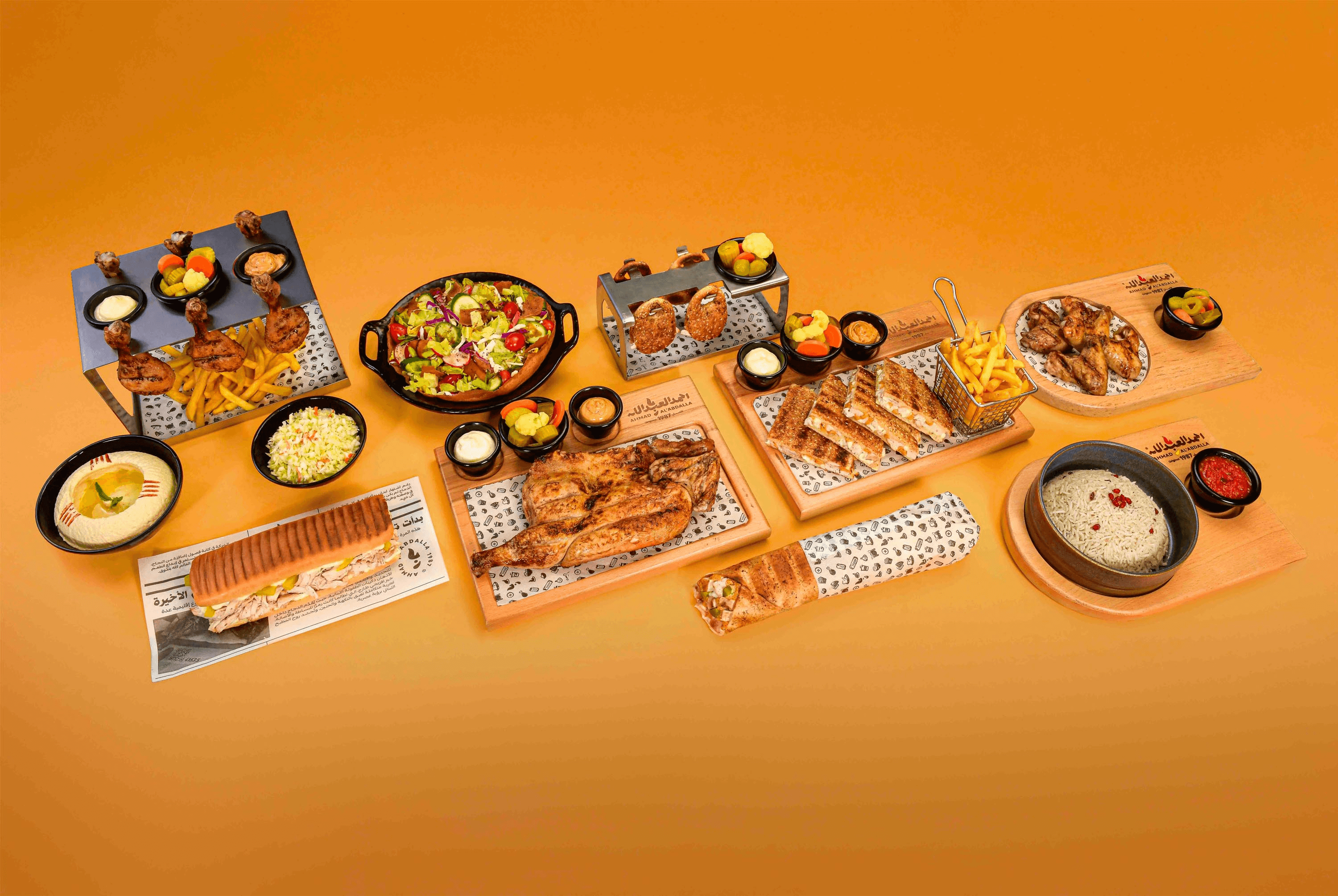 Ahmad Al’Abdalla meal spread with grilled chicken, wraps, fries, salad, and sauces