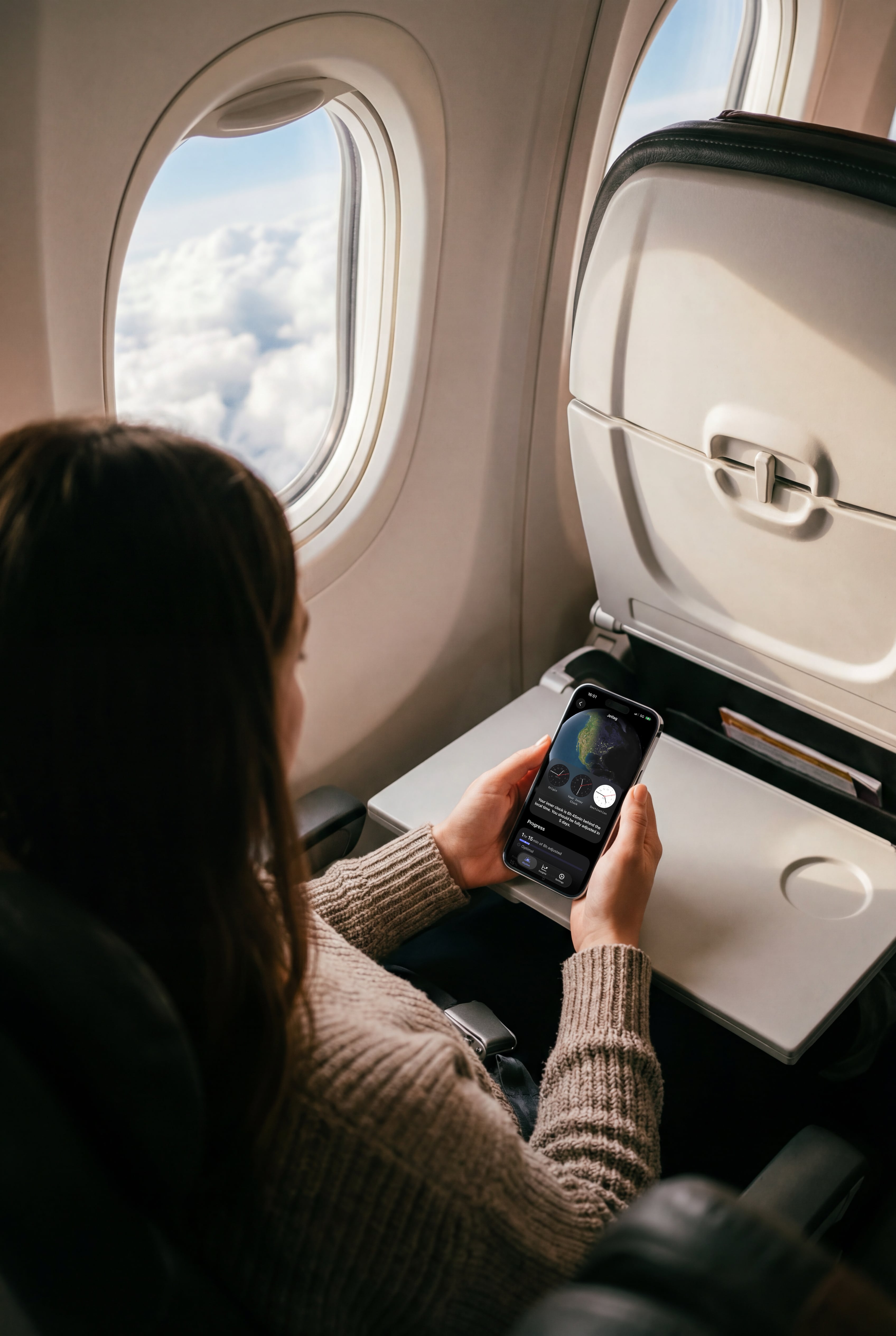 A women on a plane checking her jetlag in peaks