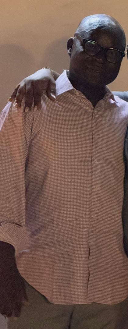 dark man in pink shirt
