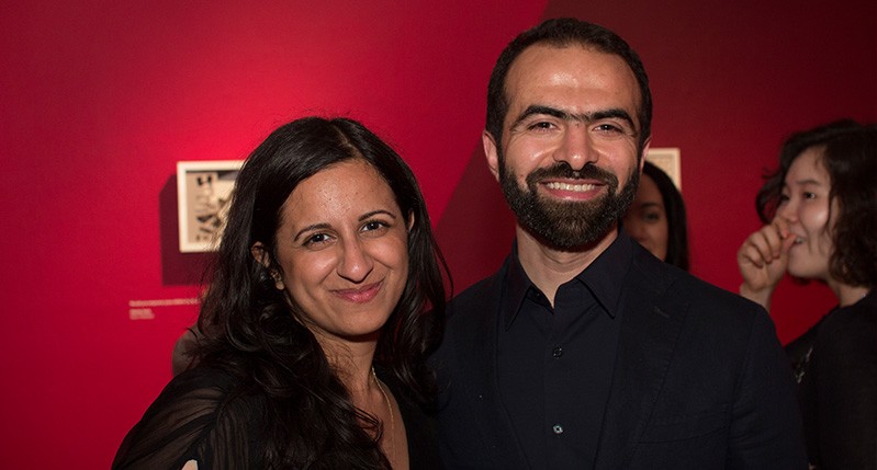 man and woman smiling in a red background