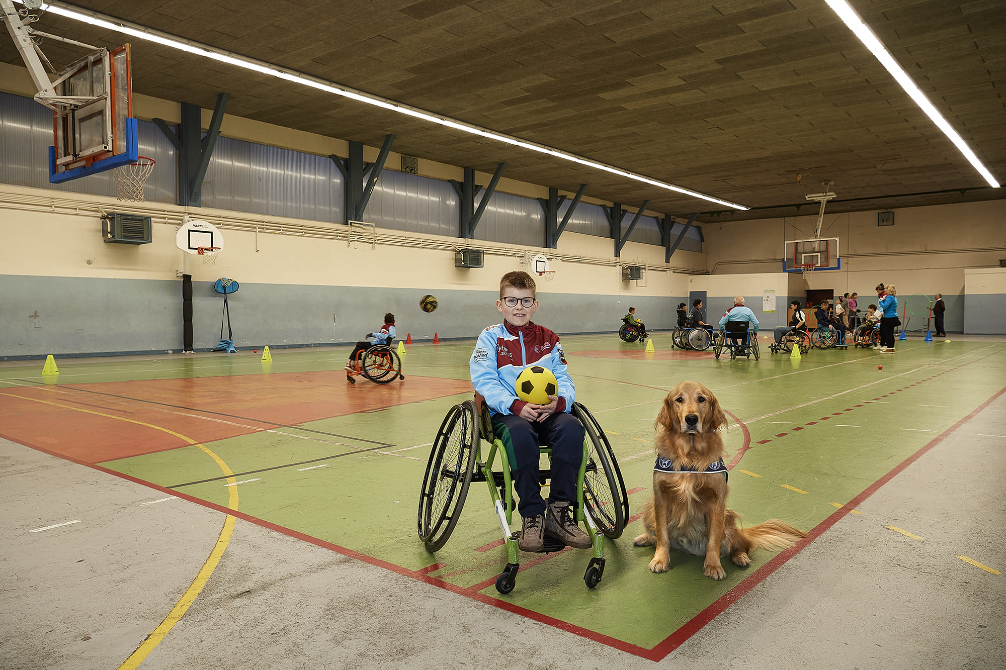 Baptiste accompagné de son chien d’assistance Raps, photographiés par Frédéric Bourcier au CSBJ Handisport de Bourgoin-Jallieu dans le cadre d’un reportage documentaire social pour Handi’Chiens.