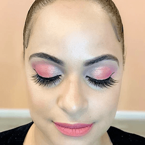 A girl with a beautiful smile stands at the reception in the Camelia beauty salon, awaiting visitors.