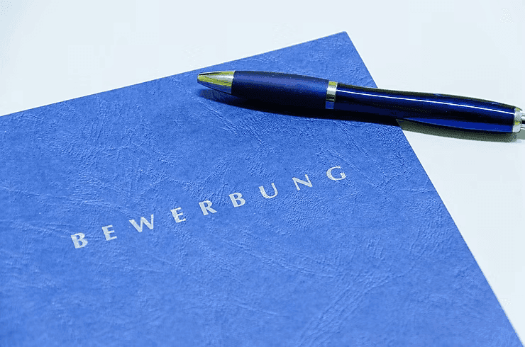 Bewerbung (blau) mit Stift. Jobsuche, Bewerbung schreiben.
