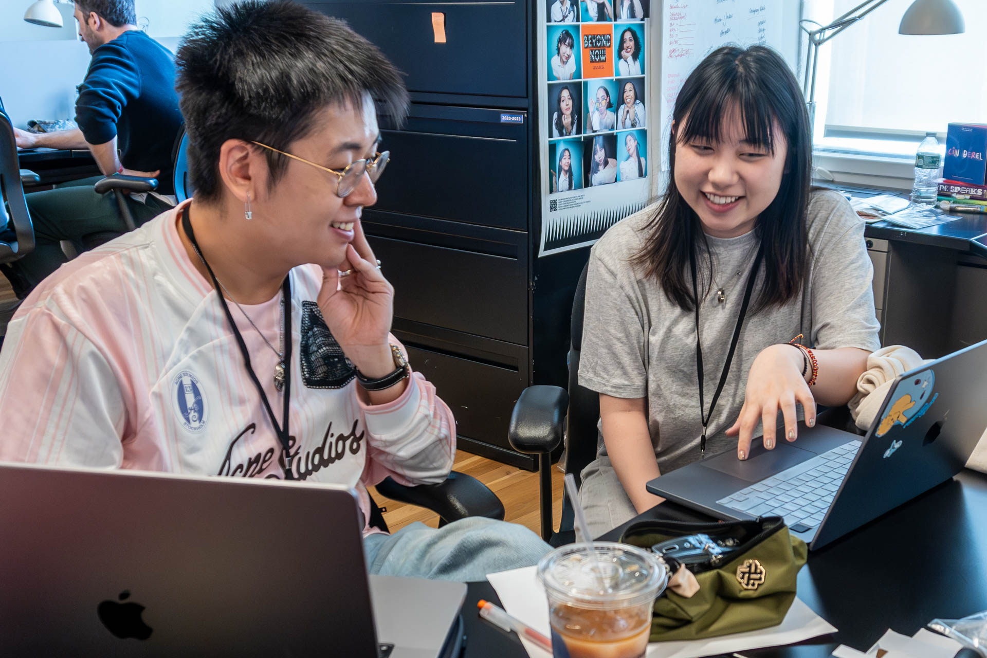 two people talking and looking at a computer