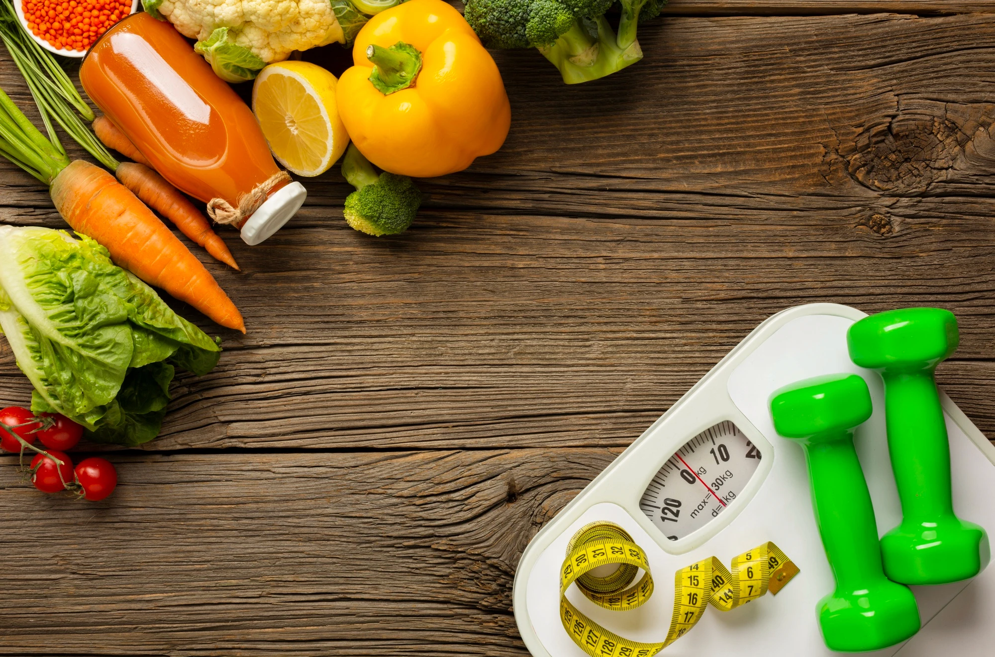 Image of healthy foods and dumbbells on a wooden surface, symbolizing common calorie-counting mistakes for better weight loss