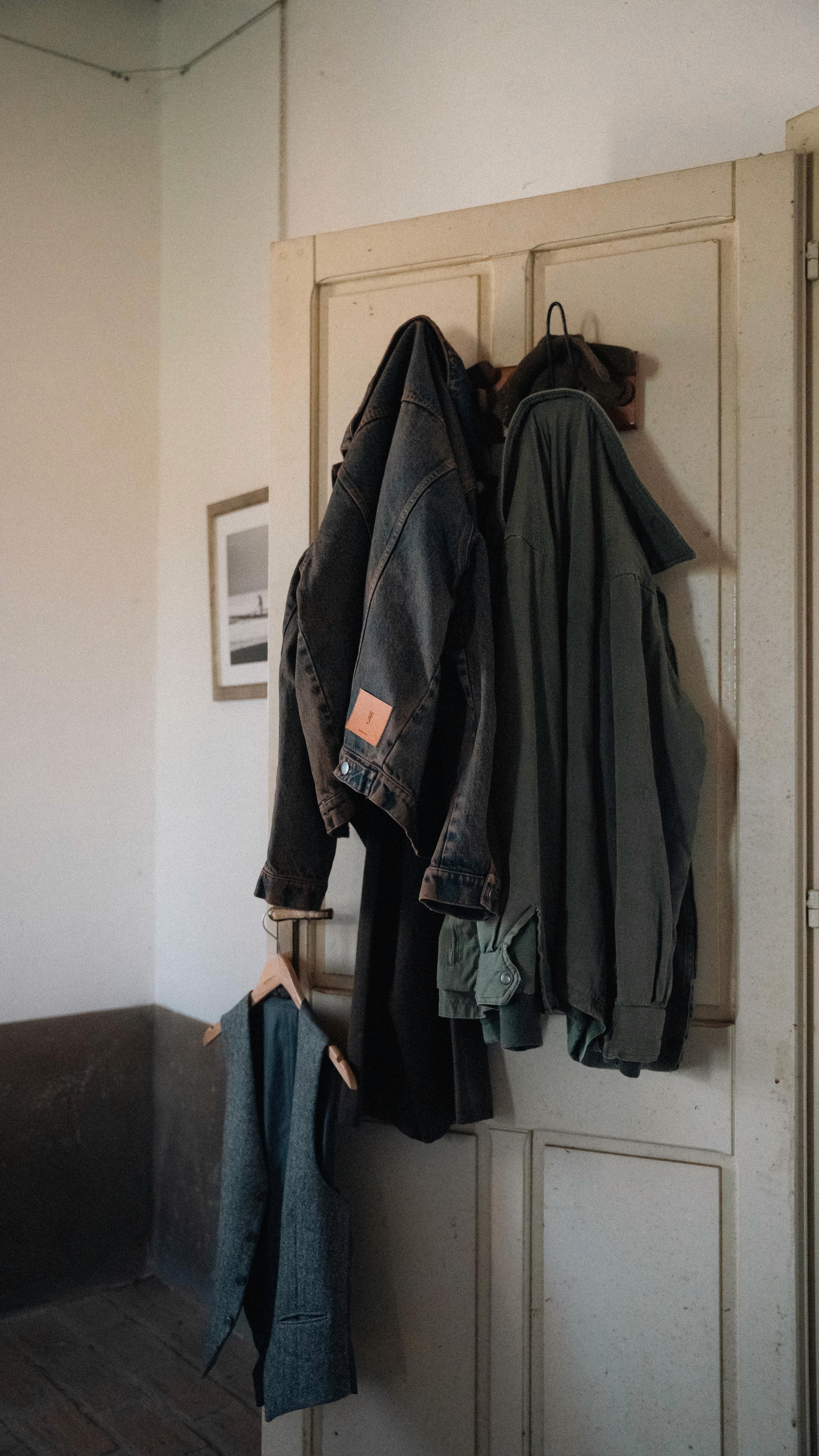 Blouson en denim et sur-chemise pour homme accrochés à unpatère dans le lookbook FW25 de Wooden Store, marque Italienne masculine