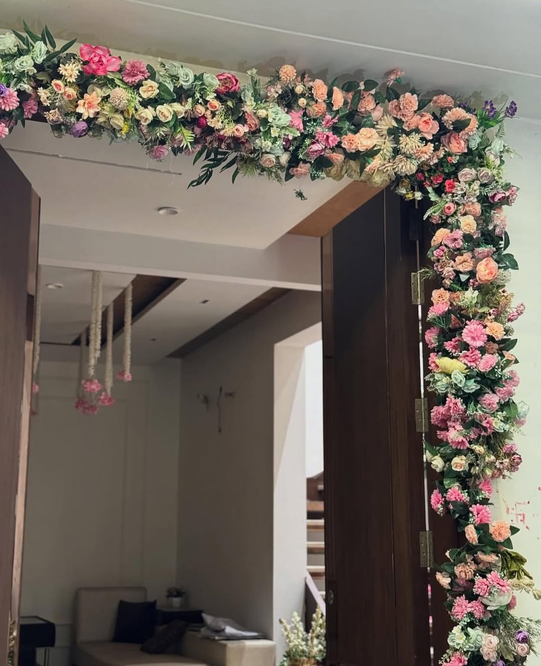 Engagement home entrance decorated with pastel roses & greenery, stylish doorway decor for roka ceremony in South Delhi NCR