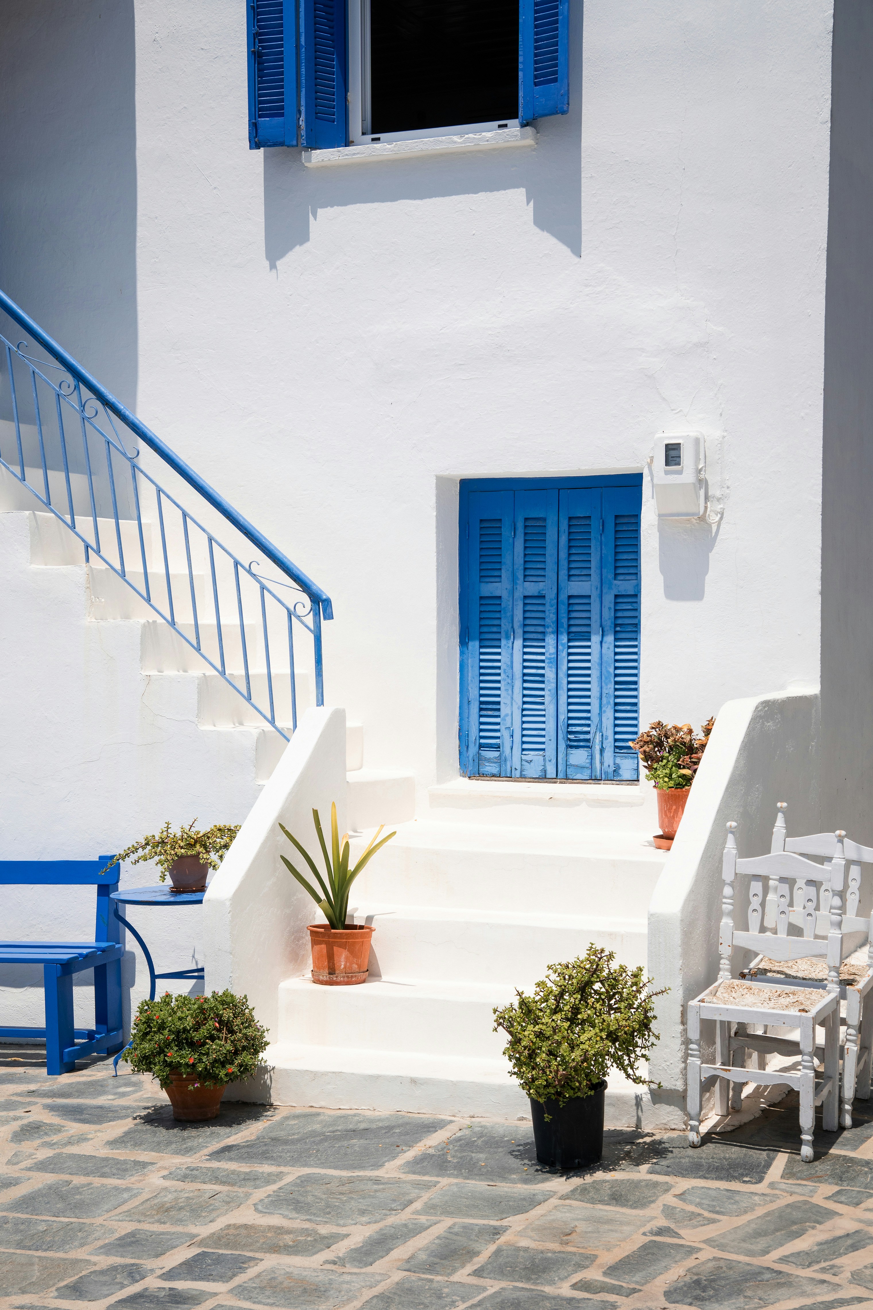 Bright white building with blue accents and greenery.